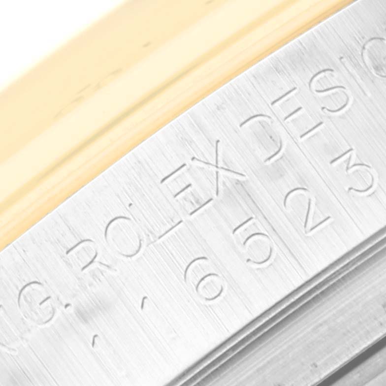 The image shows a close-up of the engraved side of a Rolex Daytona 116523G Men
s Steel and Gold (two tone) White Dial 116523G Men
s Steel and Gold (two tone) White Dial watch case.