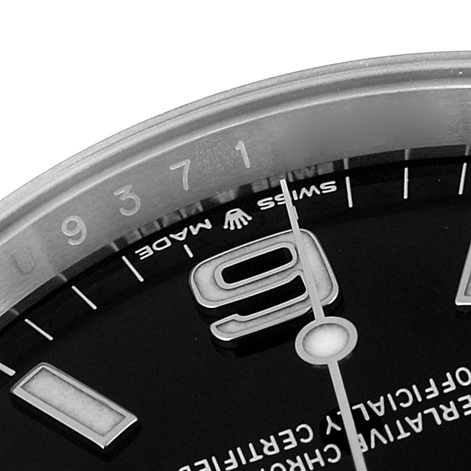 The image shows a close-up of the dial and bezel of a Rolex Explorer 124270 Men
s Stainless Steel Black Dial 124270 Men
s Stainless Steel Black Dial watch, highlighting part of the 9 o
clock numeral.