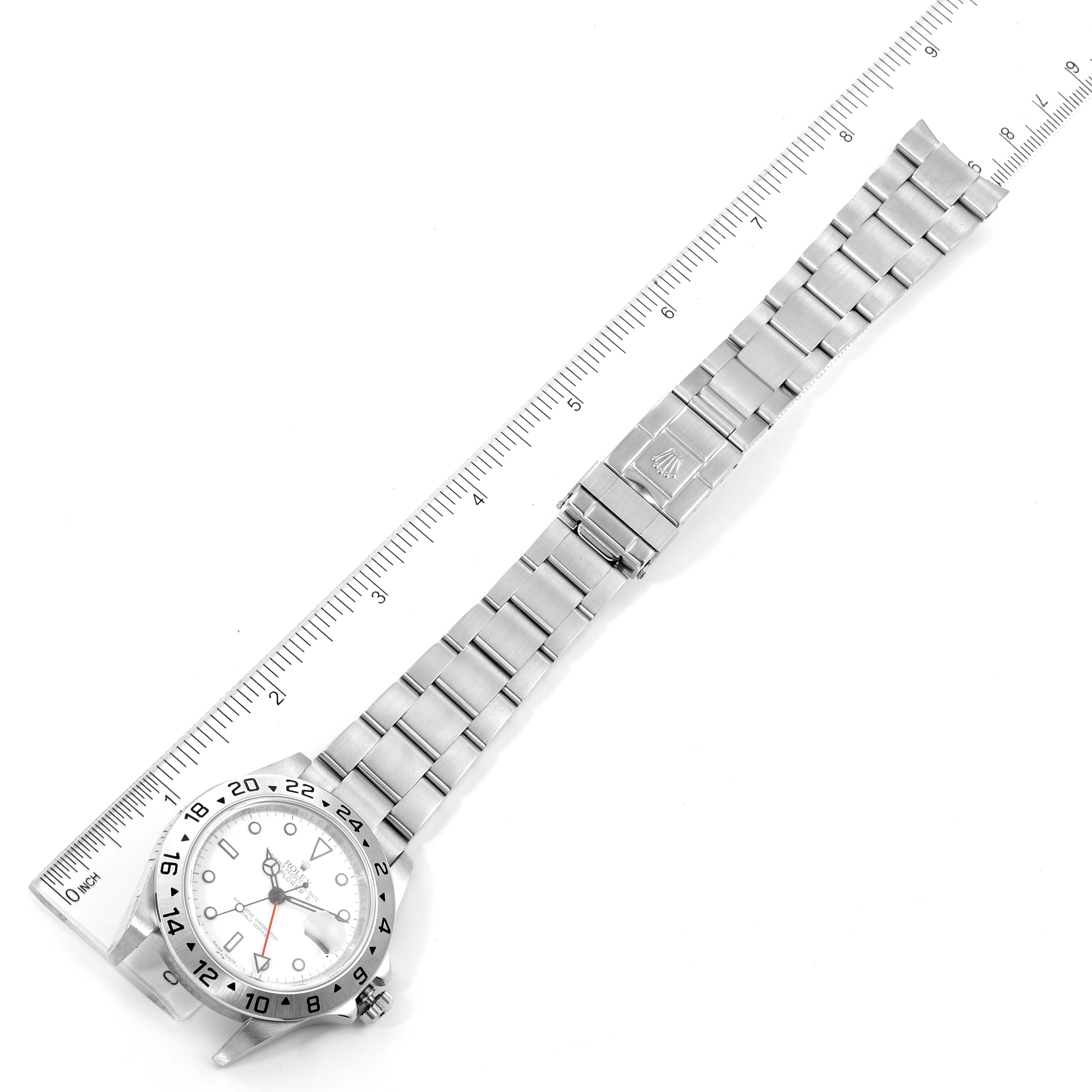 This image shows a Rolex Explorer 16570 Men's Stainless Steel White Dial 16570 Men's Stainless Steel White Dial watch laid flat with its stainless steel bracelet extended next to a ruler for scale.