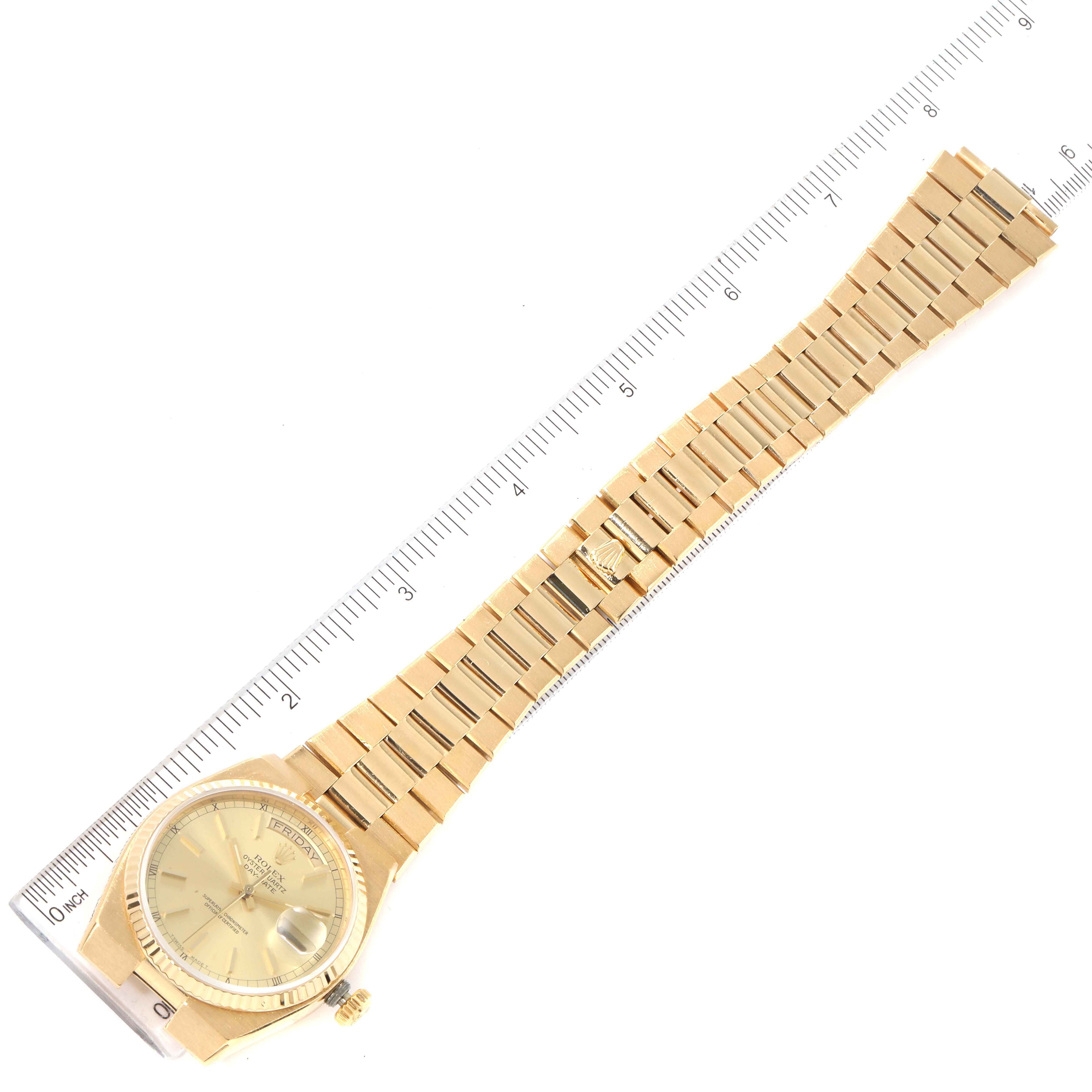 The image shows a top view of a Rolex Oysterquartz 19018 Men's Yellow Gold Champagne Dial 19018 Men's Yellow Gold Champagne Dial watch with its band laid flat next to a ruler for scale.