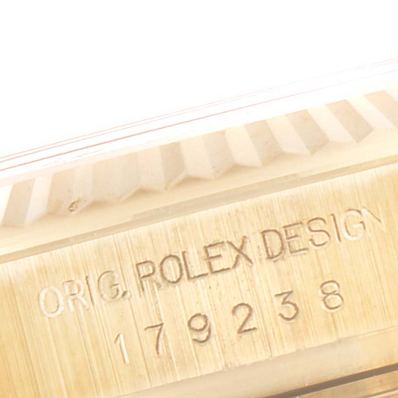 The image shows a close-up of the edge of the bezel and case side of a Rolex President 179238 Women
s Yellow Gold White Dial 179238 Women
s Yellow Gold White Dial model watch, featuring the engraved design and serial number.