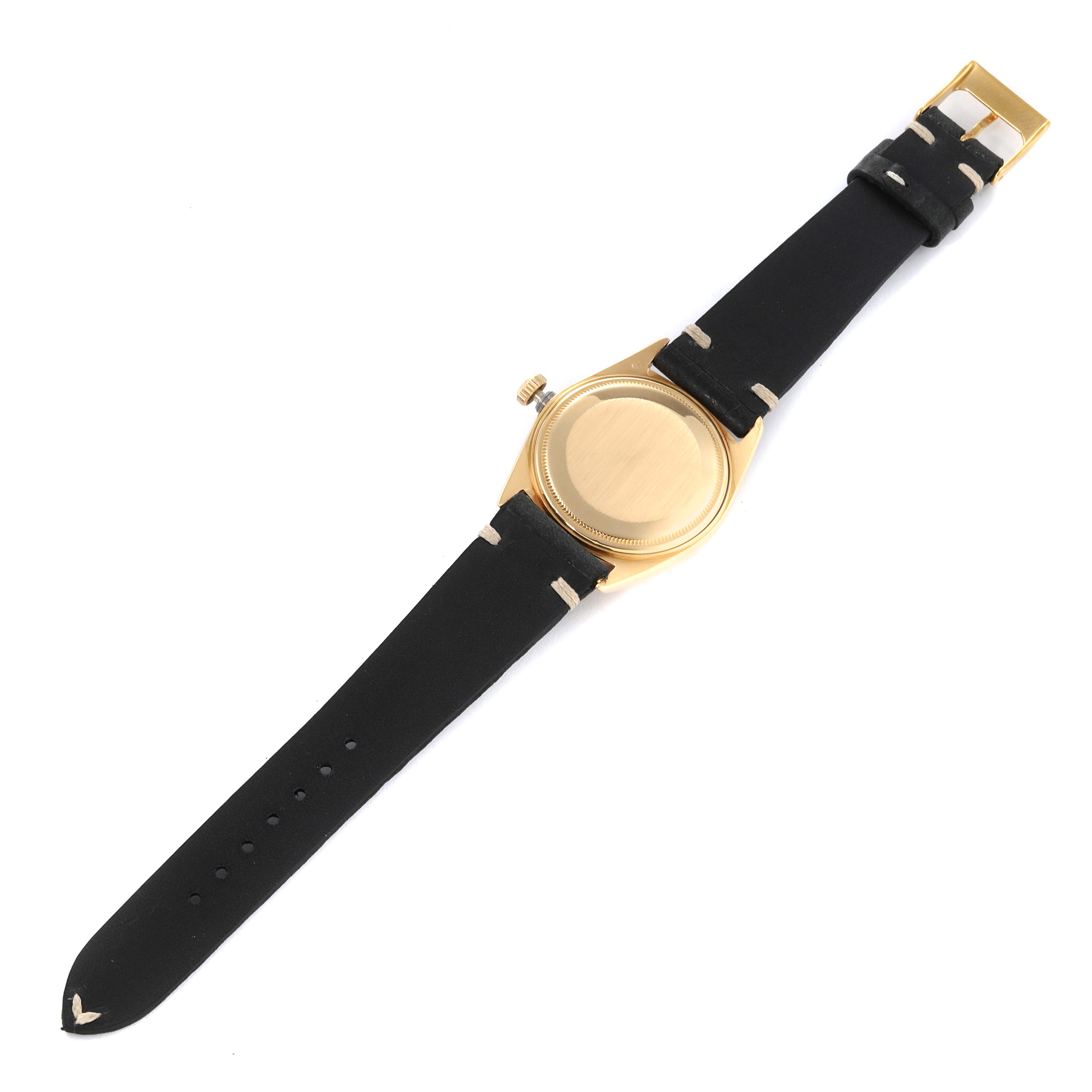This Rolex President 1803 Men's Yellow Gold Black Dial 1803 Men's Yellow Gold Black Dial watch is shown from the back, featuring its gold case and black leather strap.