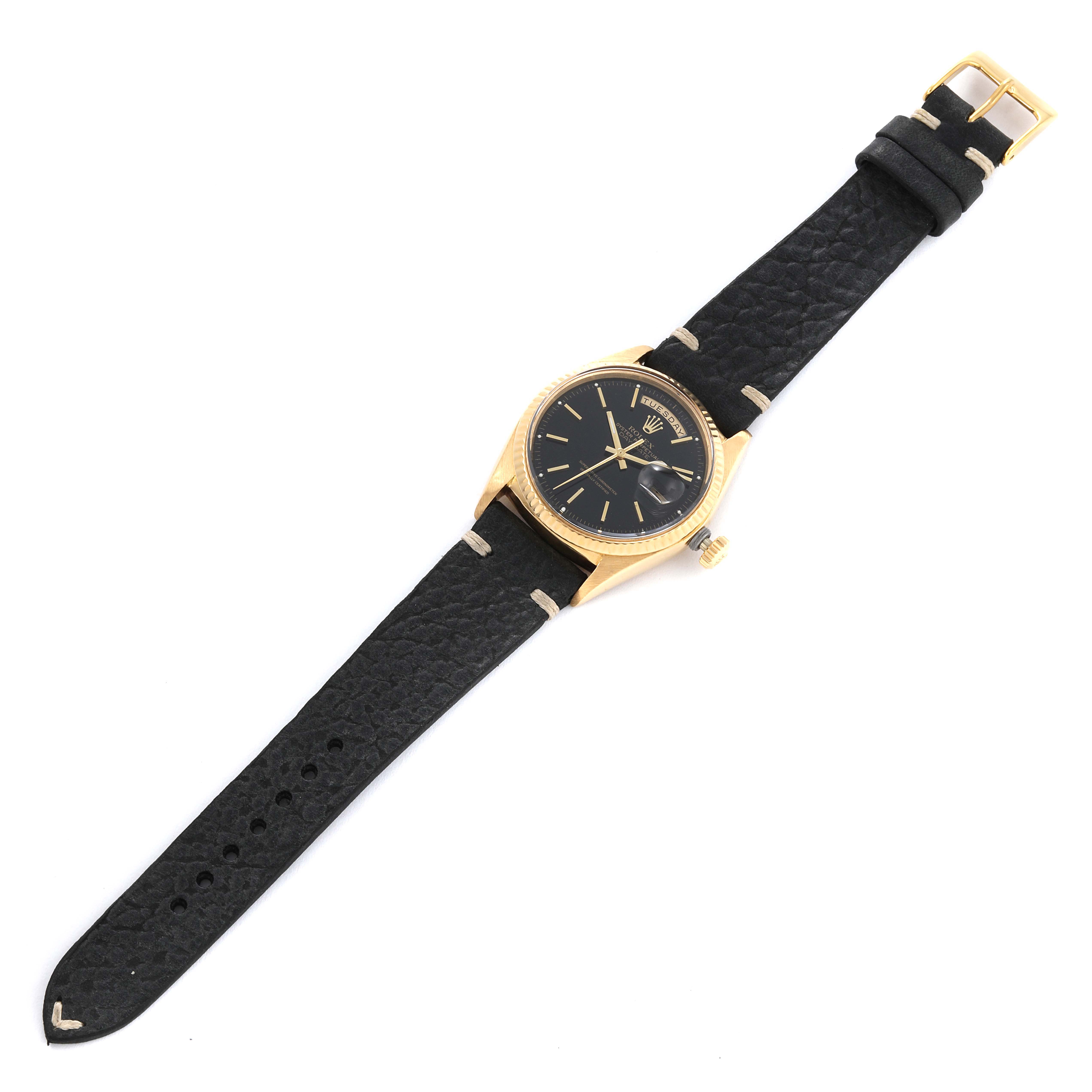 This Rolex President 1803 Men's Yellow Gold Black Dial 1803 Men's Yellow Gold Black Dial model watch is shown from a top-down angle, displaying the face, bezel, black strap, and buckle.