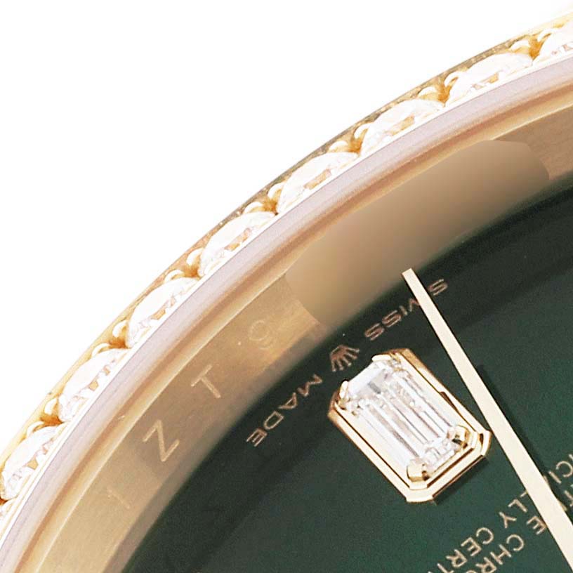 This close-up image of the Rolex President 128348RBR Men's Yellow Gold Green Dial 128348RBR Men's Yellow Gold Green Dial model watch shows part of the bezel, dial, and a diamond marker.