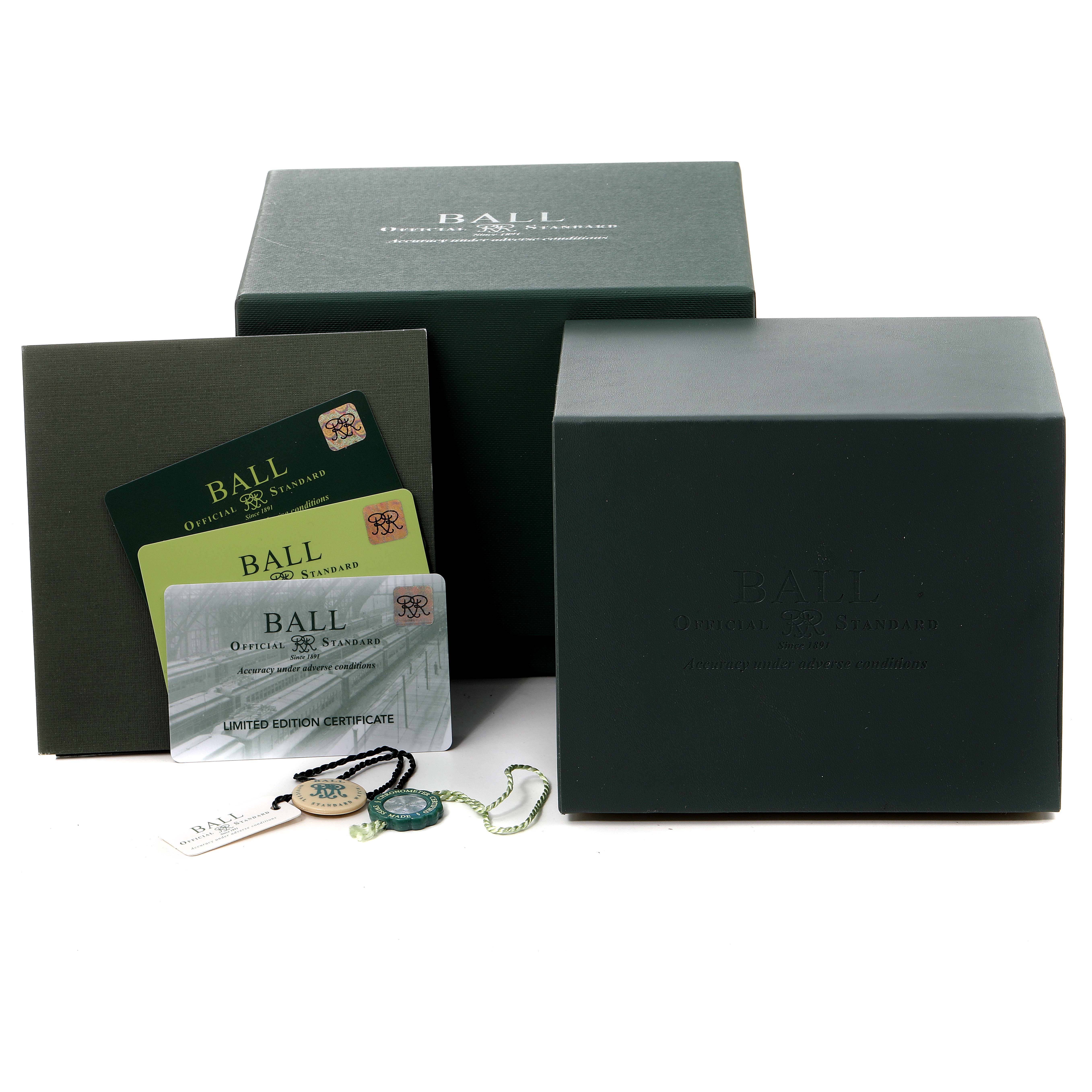 The image shows the packaging and accessories for a Ball Roadmaster DM3130B-S3CJ-GY Men's Stainless Steel Grey Dial DM3130B-S3CJ-GY Men's Stainless Steel Grey Dial watch, including the box, certificates, and tags.