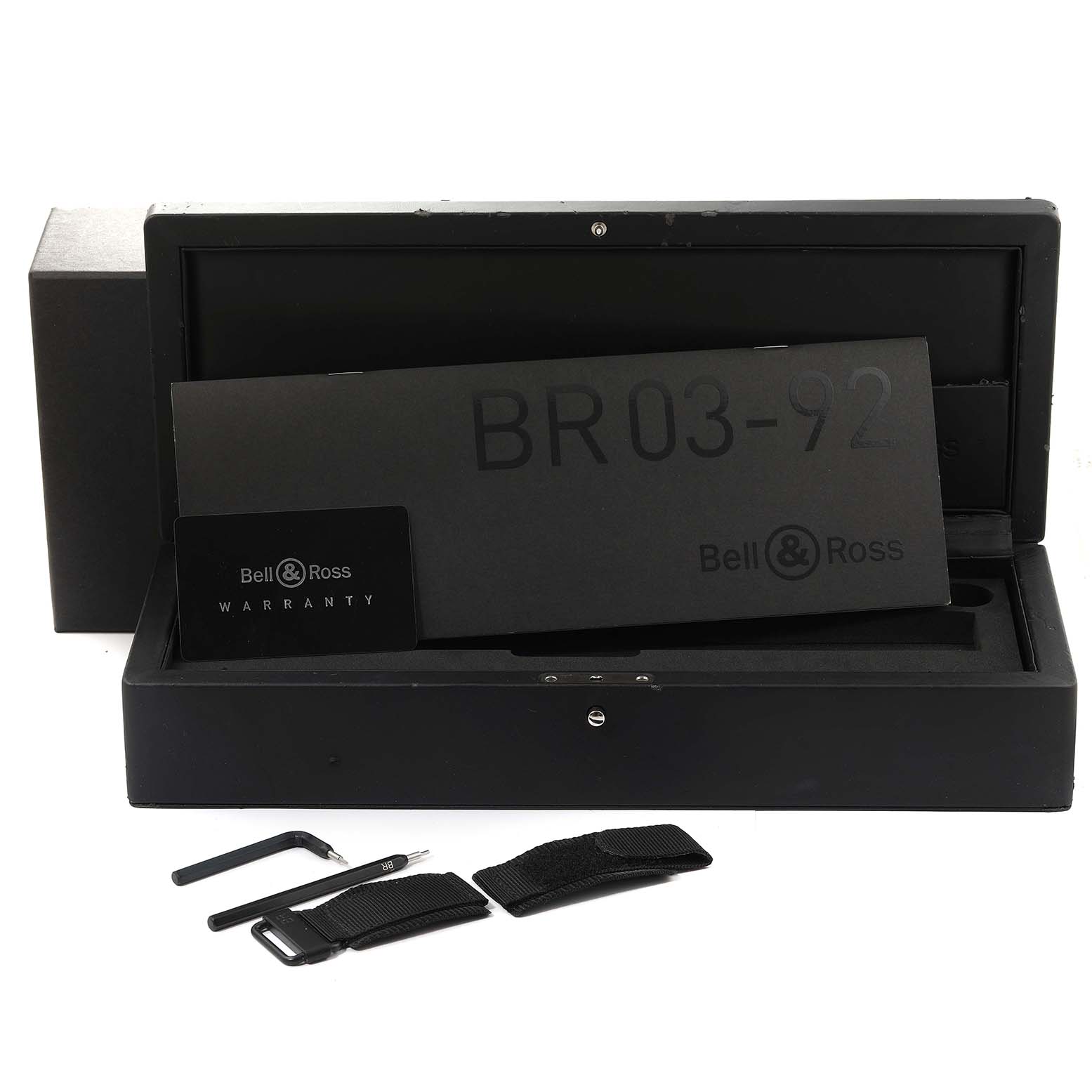 The image shows an open Bell & Ross BR03-92 Chronograph watch box with a warranty card, extra straps, and tools.