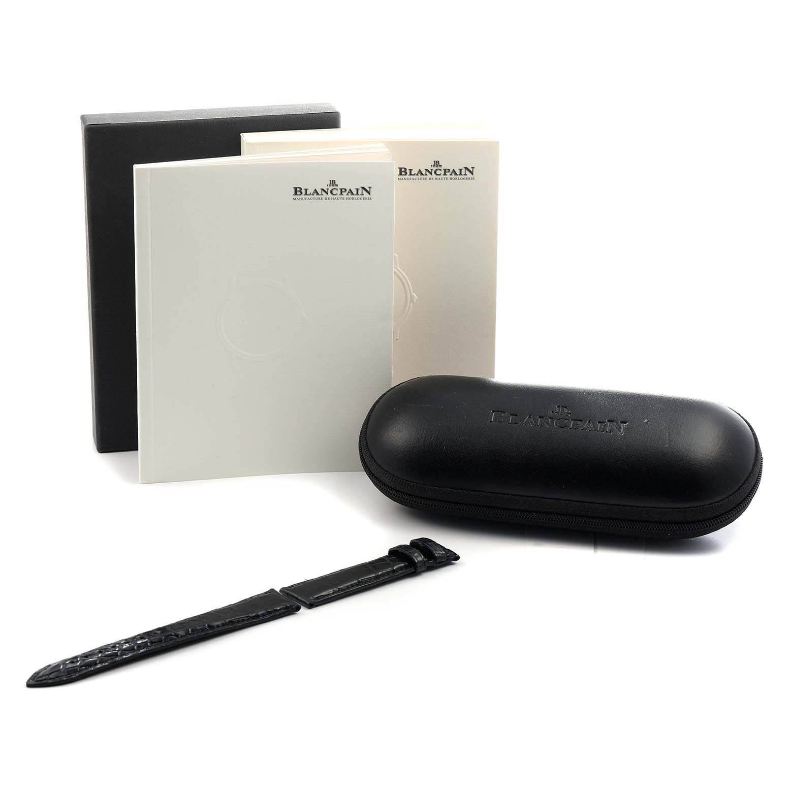 The image shows a Blancpain Villeret 2160-3630-53B Men's Rose Gold Black Dial model accessory set with a leather strap, a black case, and brand booklets from a front angle.