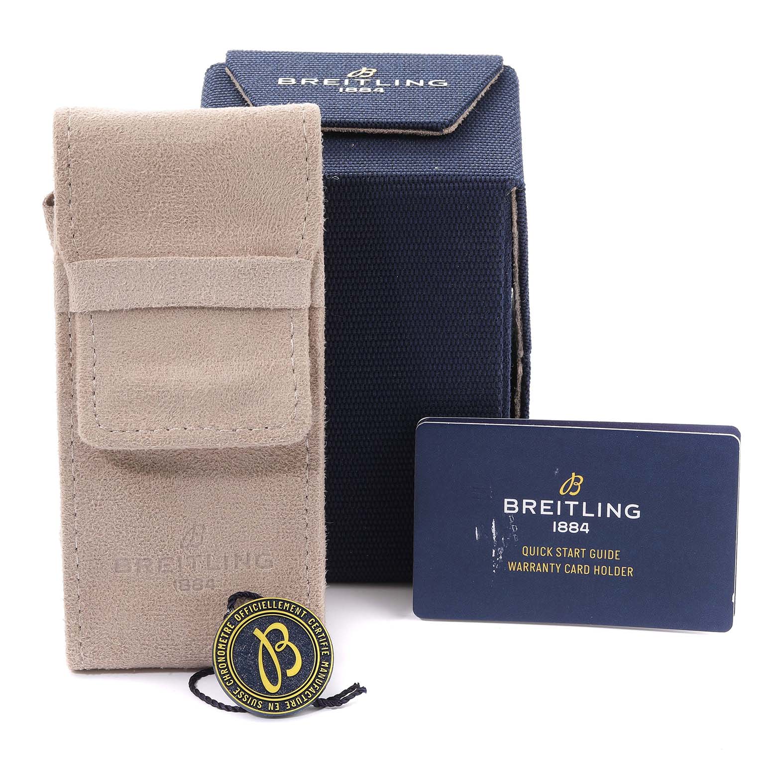 The image shows the accessories of a Breitling Superocean A17375 Men's Stainless Steel White Dial A17375 Men's Stainless Steel White Dial watch, including a beige case, blue box, warranty card holder, and tag.