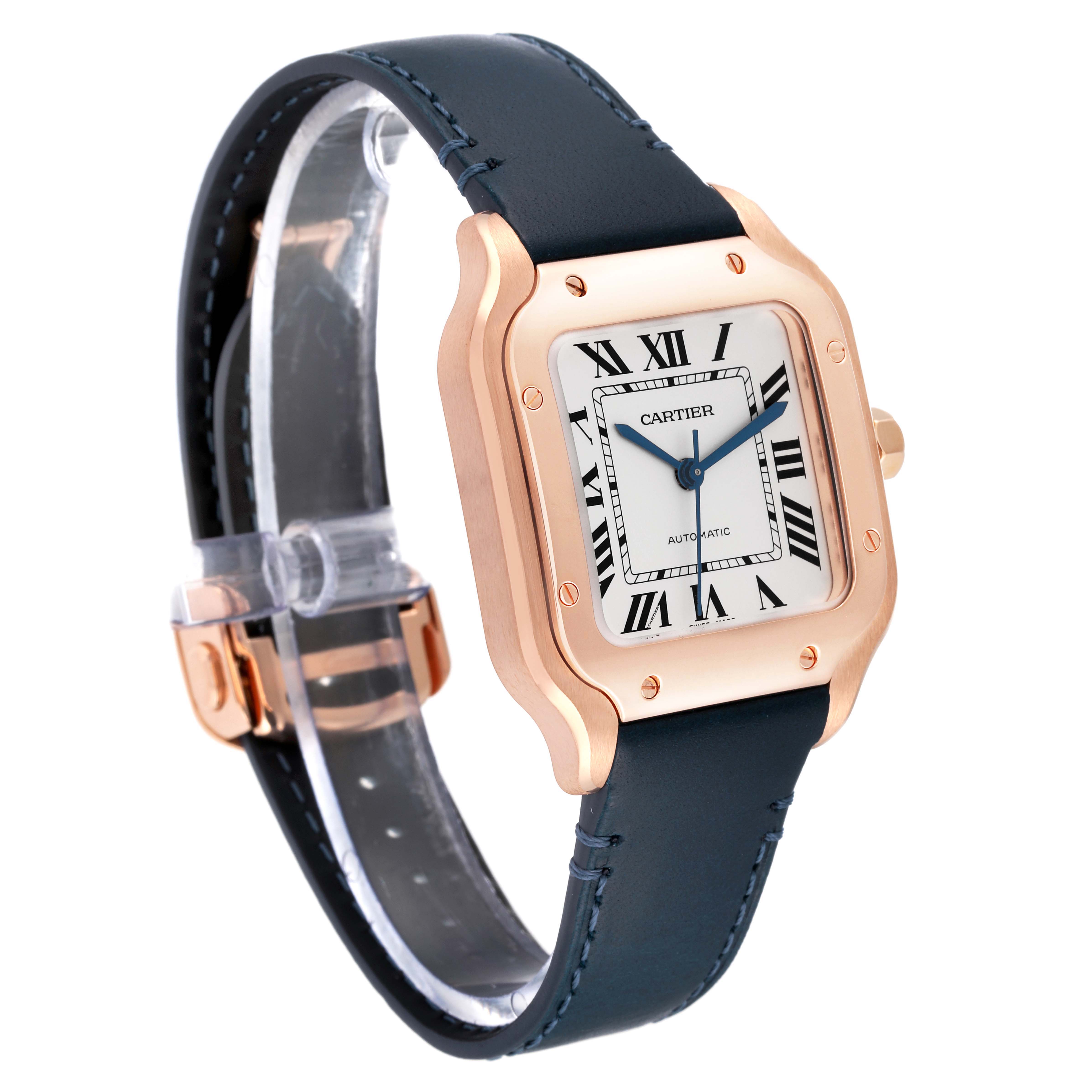 The image shows a Cartier Santos WGSA0028 Men
s Rose Gold Silver Dial WGSA0028 Men
s Rose Gold Silver Dial model watch at a three-quarter angle, highlighting its gold case, blue hands, and black leather strap.