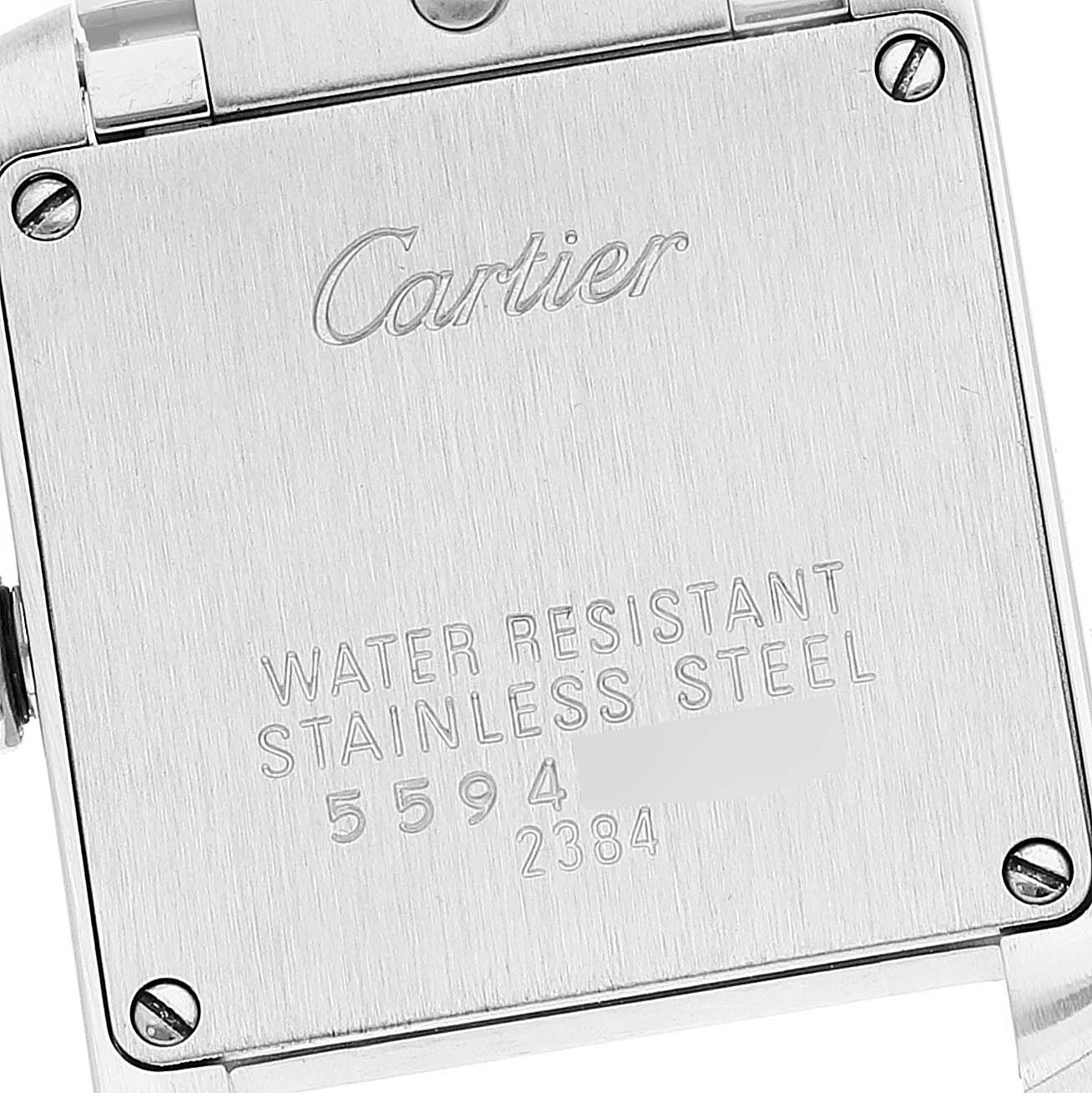 The image shows the back of a Cartier Tank Française watch, highlighting its stainless steel case with engraved text and serial numbers.