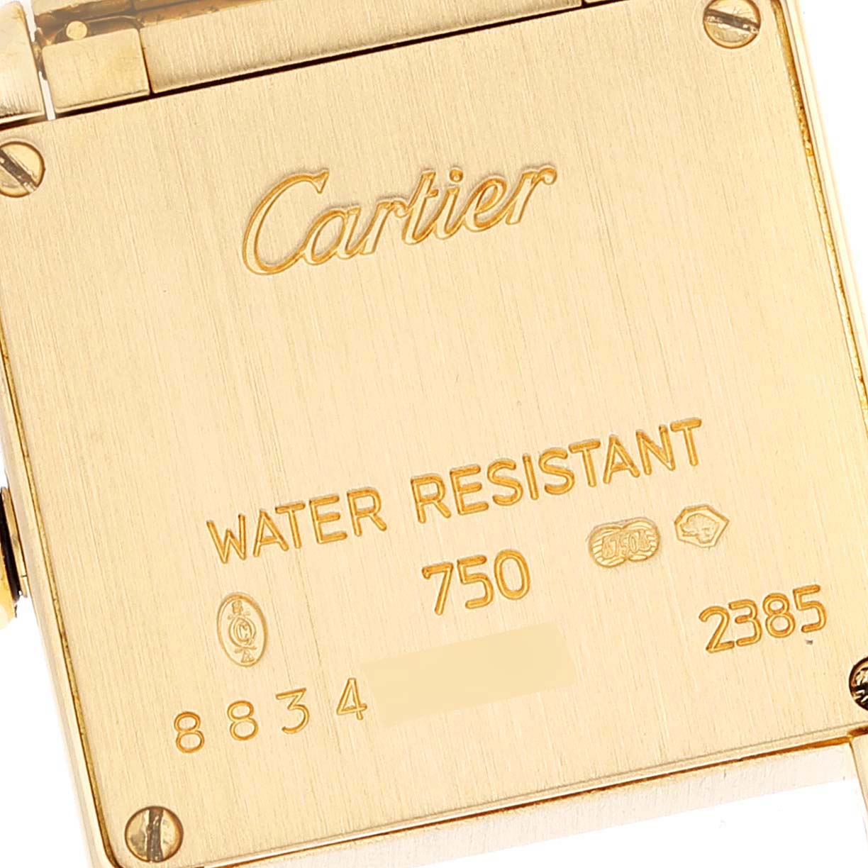 This is a close-up of the back case of a Cartier Tank Francaise W50002N2 Women's Yellow Gold Silver Dial W50002N2 Women's Yellow Gold Silver Dial watch, showing the brand name, water resistance, and other markings.