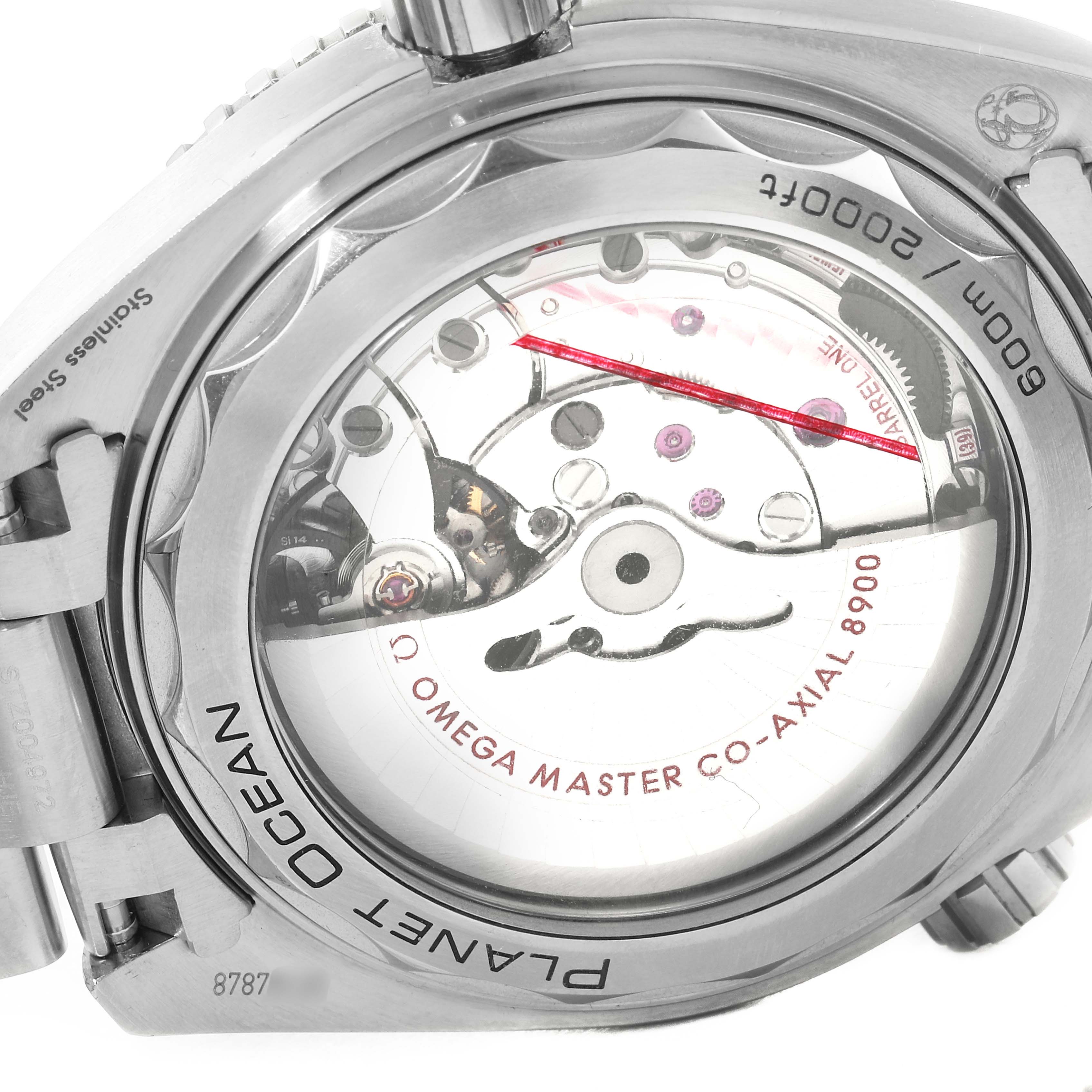 The image shows the back of an Omega Planet Ocean 215.30.44.21.01.001 Men's Stainless Steel Black Dial 215.30.44.21.01.001 Men's Stainless Steel Black Dial watch, focusing on its exposed movement and "Omega Master Co-Axial 8900" markings.