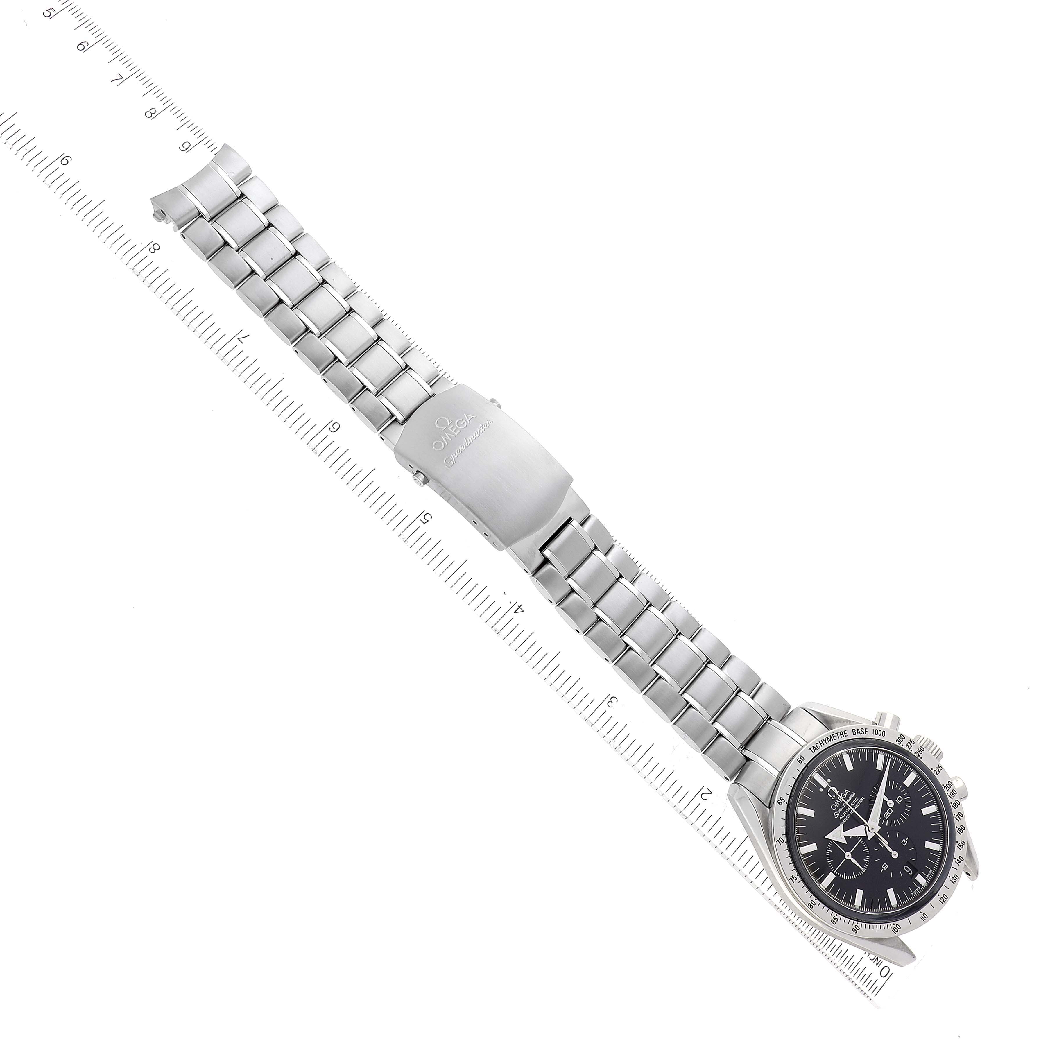 The image shows an Omega Speedmaster 3551.50.00 Men
s Stainless Steel Black Dial 3551.50.00 Men
s Stainless Steel Black Dial watch laid flat with a focus on its full stainless steel bracelet and clasp, alongside a ruler for scale.