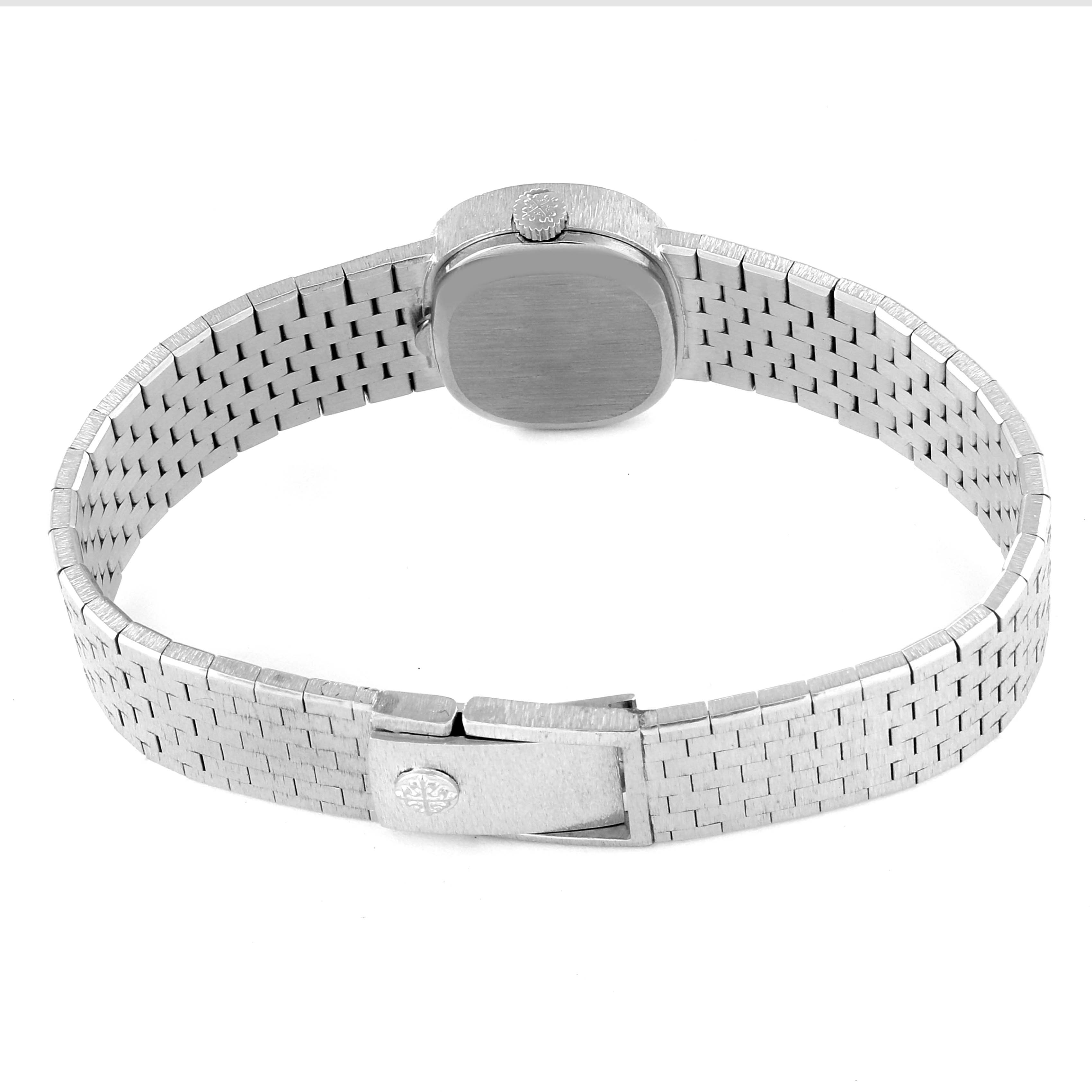 This image shows the back of a Vintage Patek Philippe watch, featuring its metal case, woven bracelet, and clasp.