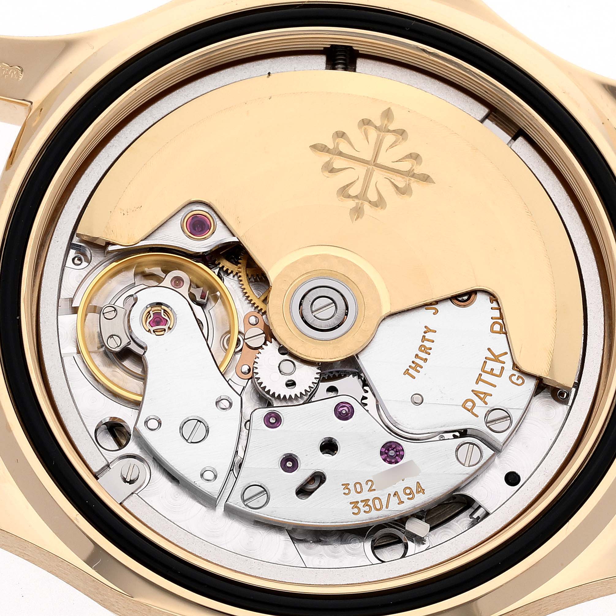 The image shows the intricate mechanical movement of a Patek Philippe Aquanaut 5060J Men's Yellow Gold Black Dial 5060J Men's Yellow Gold Black Dial watch from the back, highlighting its gears and rotor.