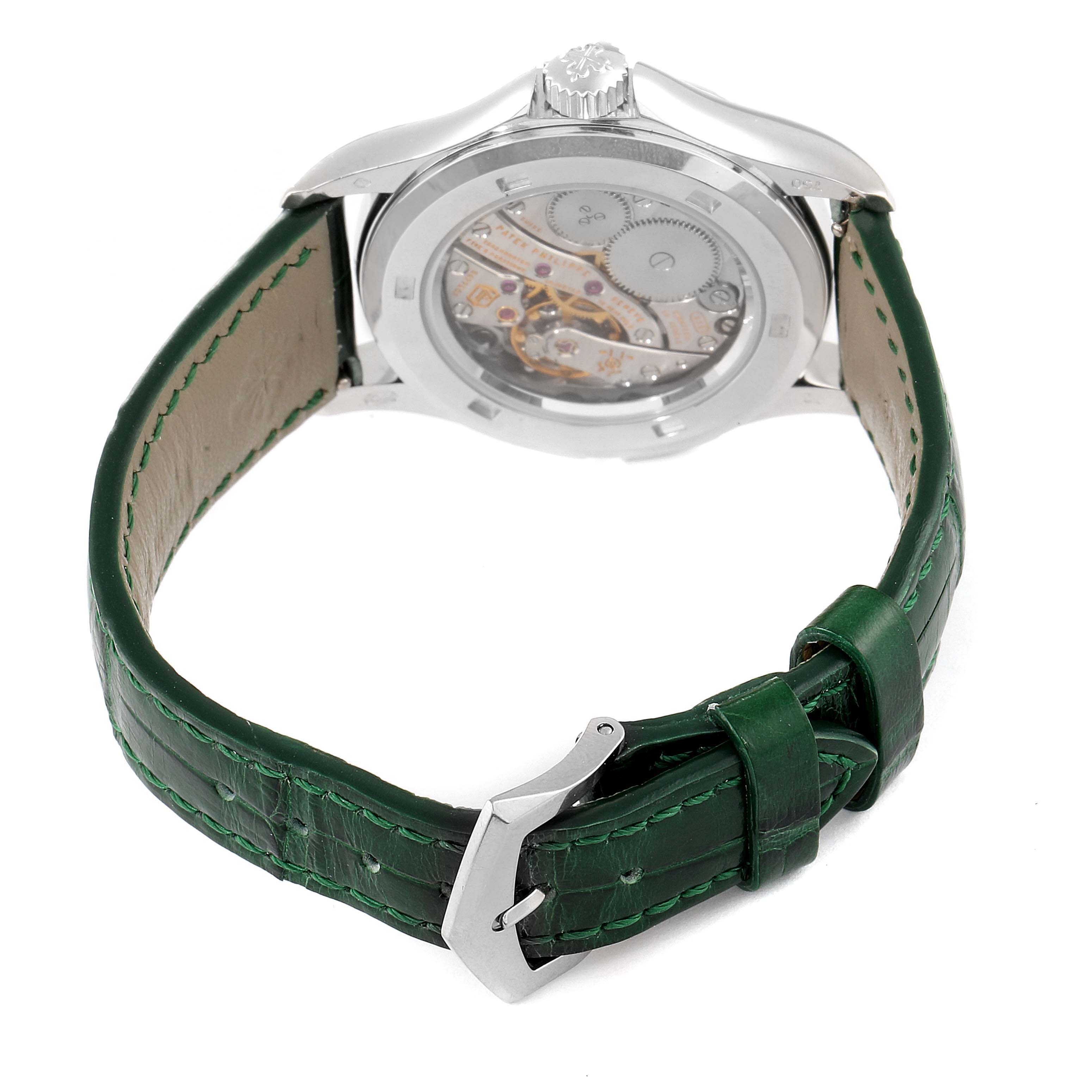 The image shows the back view of a Patek Philippe Calatrava 4934G Women's White Gold Mother of Pearl Dial 4934G Women's White Gold Mother of Pearl Dial watch, highlighting its movement and a green leather strap.