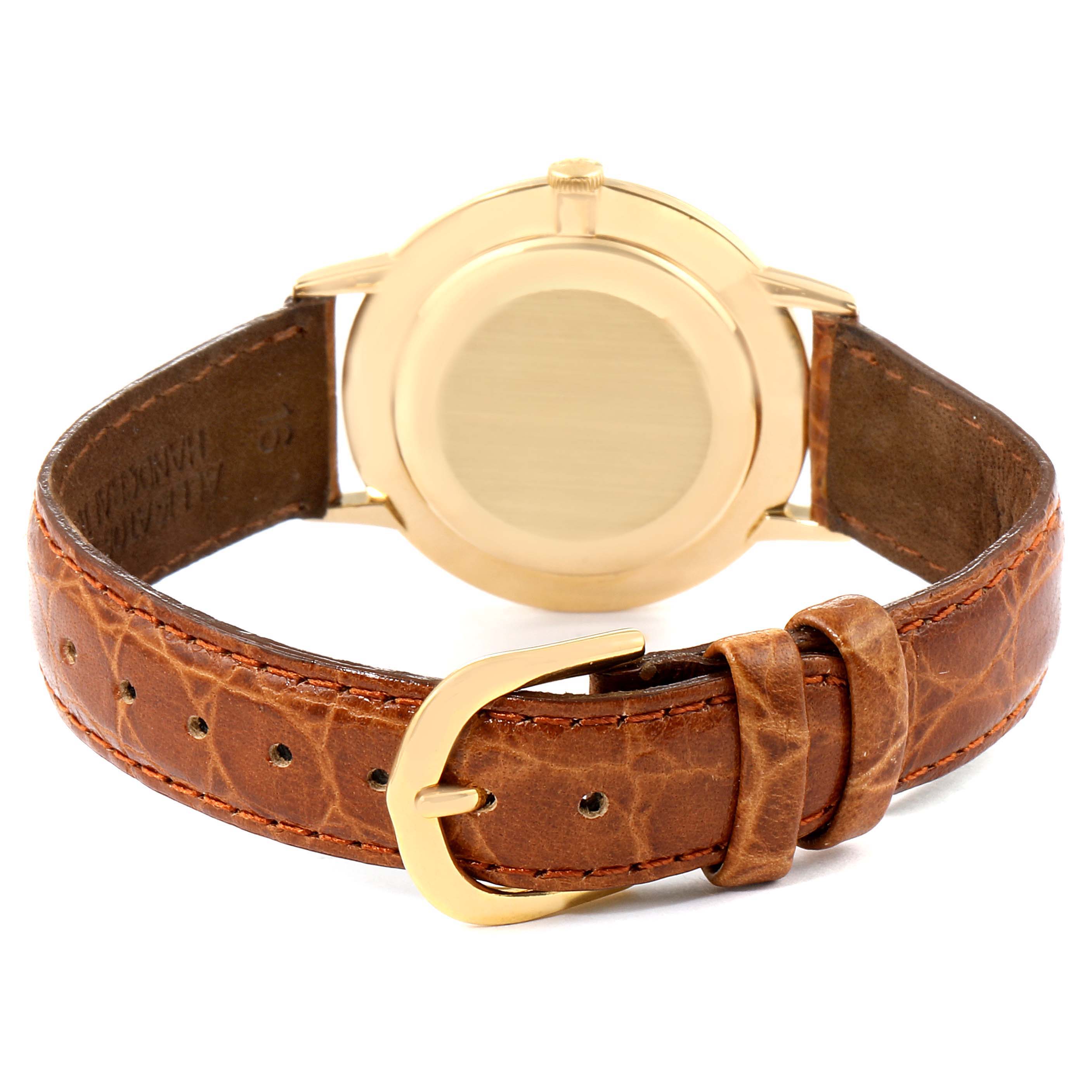 This image shows the back view of a Vintage Patek Philippe watch, focusing on the gold case and brown leather strap with a gold buckle.