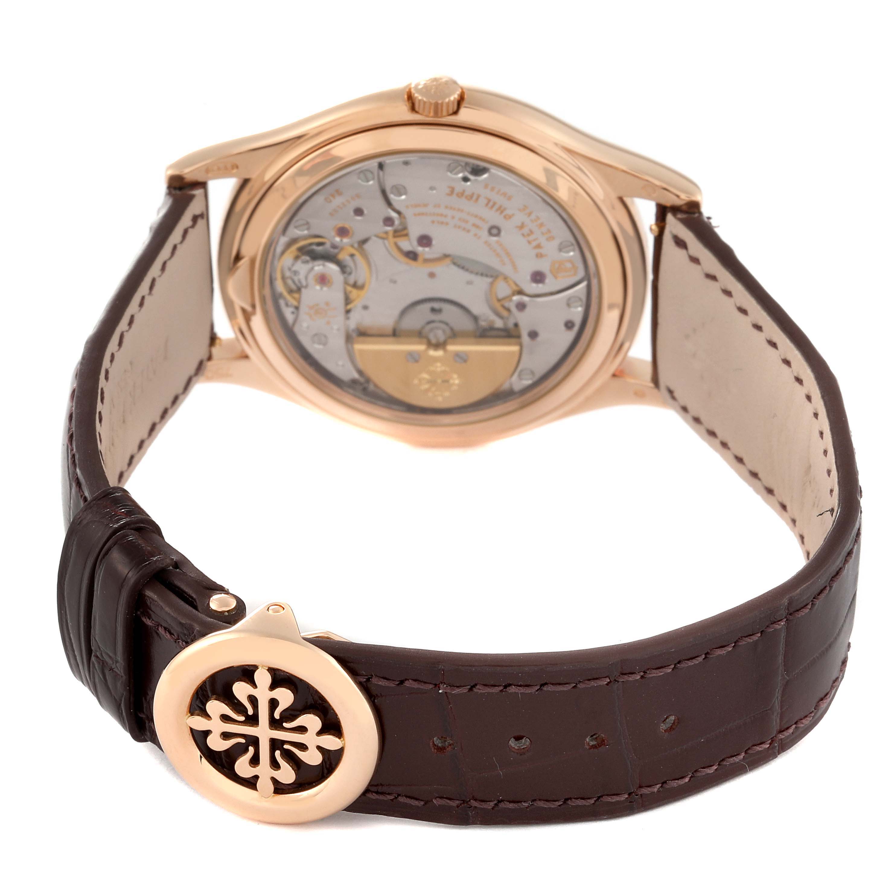 This image shows the backside of a Patek Philippe Complications 5140R-001 Men
s Rose Gold Silver Dial 5140R-001 Men
s Rose Gold Silver Dial watch, highlighting the movement and leather strap with the brand
s logo.