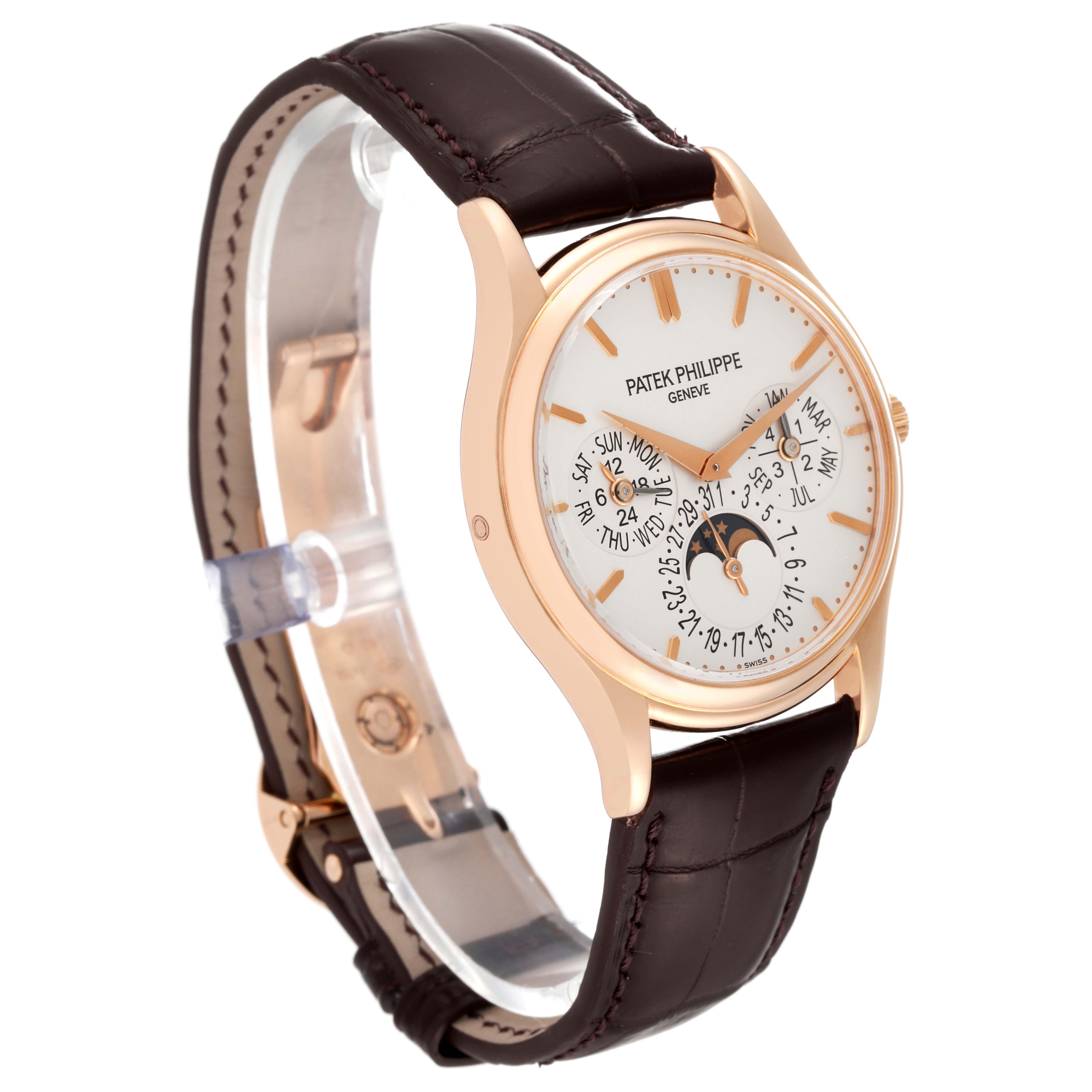 The image shows a Patek Philippe Complications 5140R-001 Men
s Rose Gold Silver Dial 5140R-001 Men
s Rose Gold Silver Dial model watch at a side angle, featuring its dial, case, and leather strap.