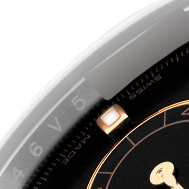 A close-up of a Rolex Daytona 116503 Men
s Steel and Gold (two tone) Black Dial 116503 Men
s Steel and Gold (two tone) Black Dial watch, showing part of the bezel with the numbers "4" and "5," and part of the dial with "SWISS MADE."