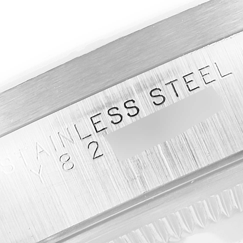 The image shows a close-up of the side of a Rolex Date 15210 Men's Stainless Steel Black Dial 15210 Men's Stainless Steel Black Dial model watch with "STAINLESS STEEL" engraved on it.