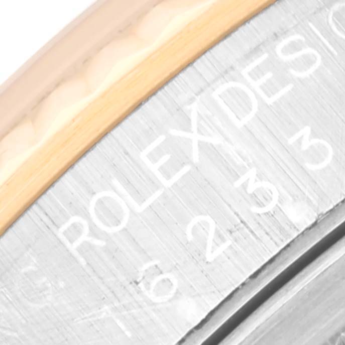 This close-up image shows the engraved "ROLEX DESIGN" inscription on the side of a Rolex Datejust 16233 Men's Steel and Gold (two tone) Black Dial 16233 Men's Steel and Gold (two tone) Black Dial watch case.