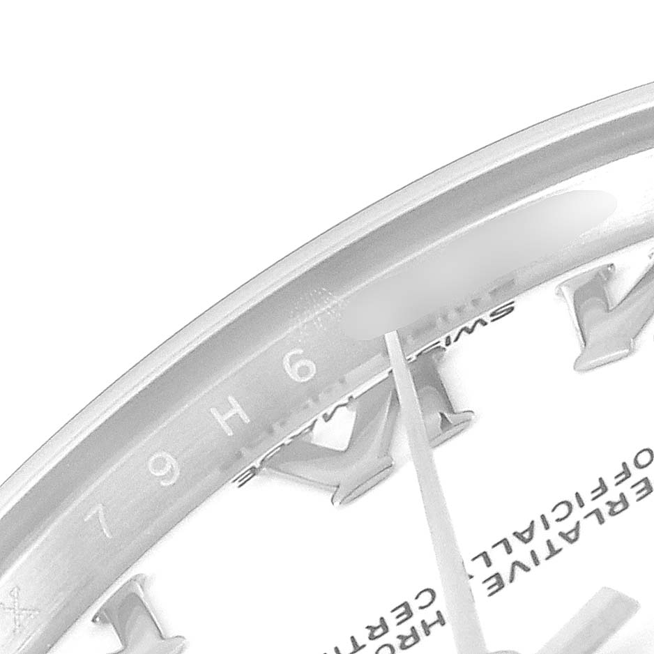The image shows a partial close-up of the Rolex Mid-Size 178274 Women
s Stainless Steel White Dial 178274 Women
s Stainless Steel White Dial dial and bezel at an angle, focusing on the numbers and markers.