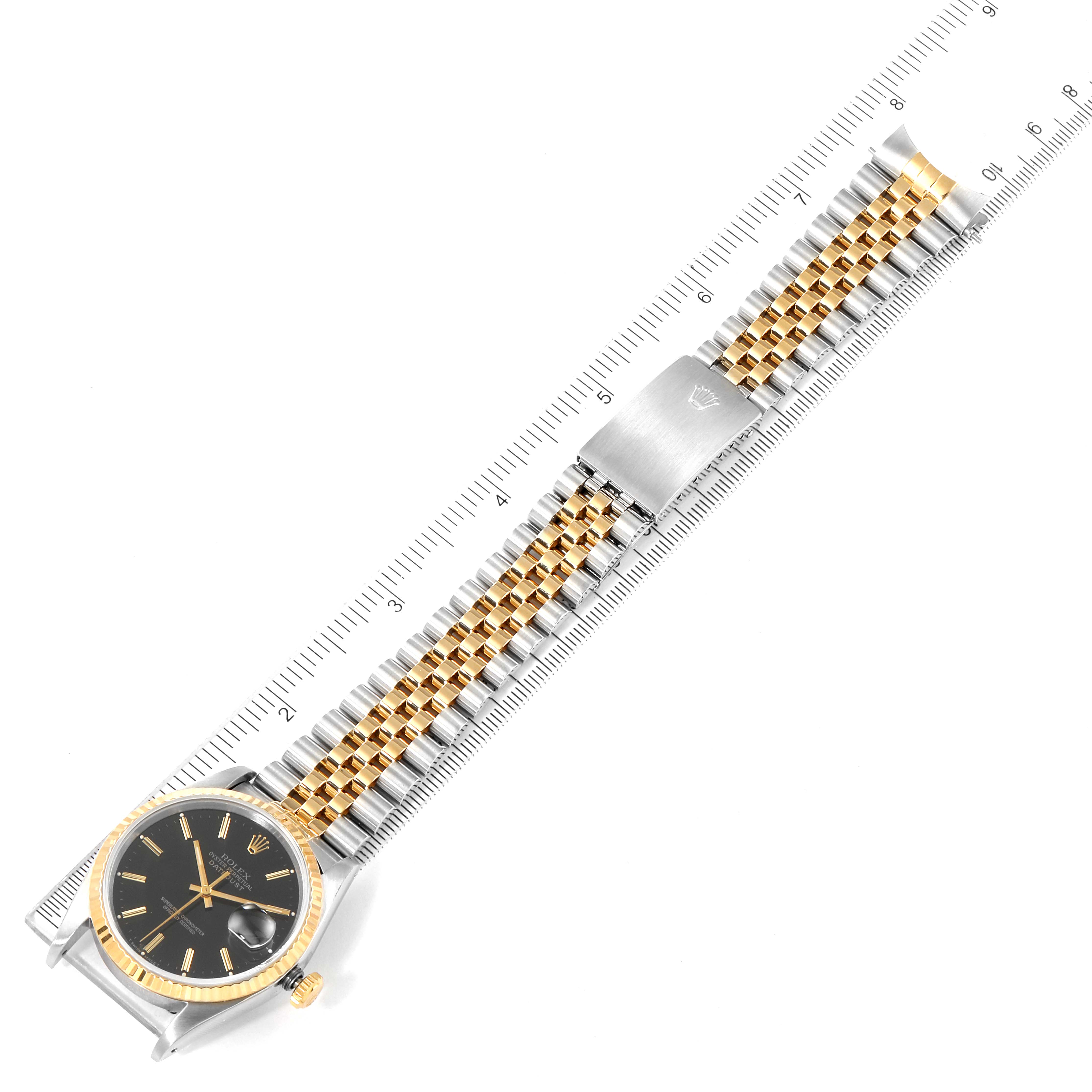 The image shows an overhead view of a Datejust Rolex watch, including the dial, bezel, and entire bracelet laid out flat against a ruler.