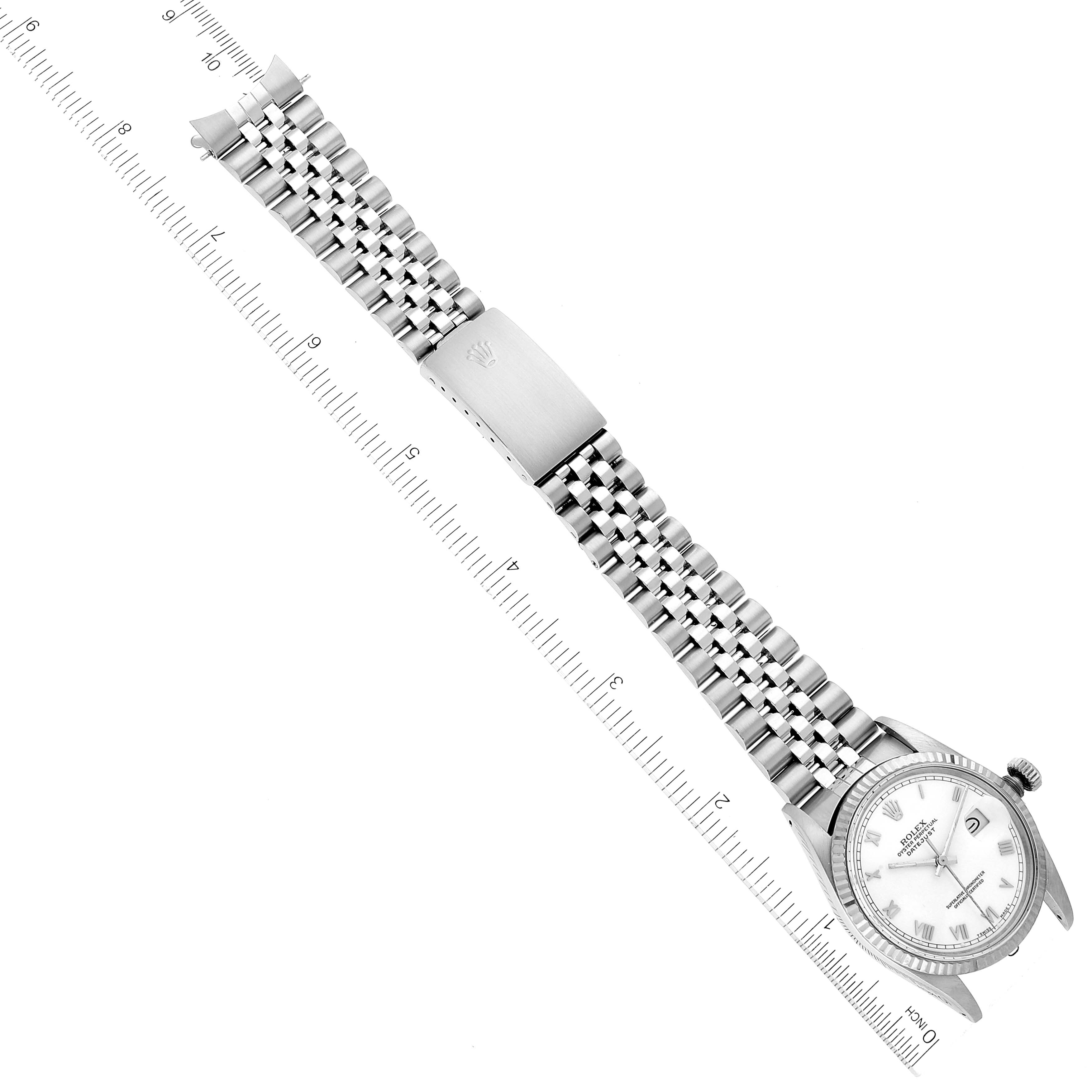 The image shows a Rolex Datejust 16014 Men's Stainless Steel White Dial 16014 Men's Stainless Steel White Dial watch laid flat with the bracelet and clasp visible, alongside a ruler for scale.