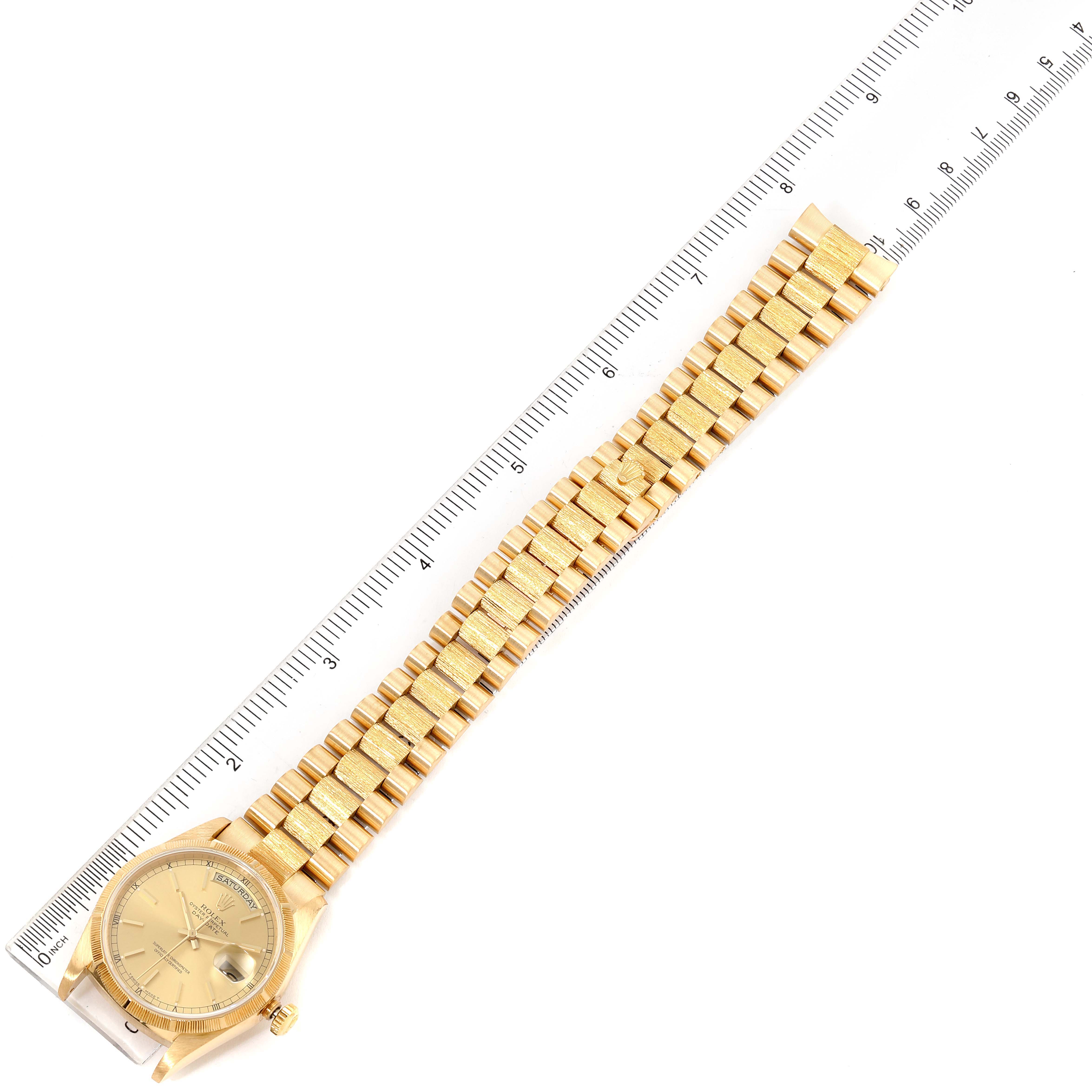 The image shows a top-down view of a Rolex President 1989-1990 Men
s Yellow Gold Champagne Dial 1989-1990 Men
s Yellow Gold Champagne Dial model watch next to a ruler, displaying its full length.