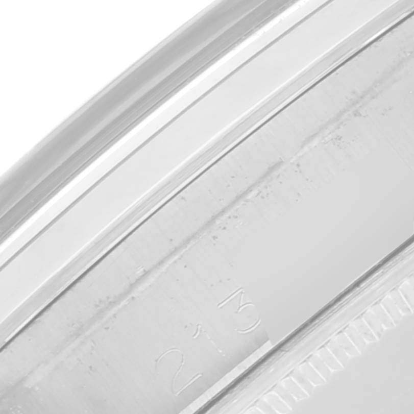 The image shows a close-up of the edge of the Rolex Oyster Perpetual 1002 Men's Stainless Steel Grey Dial 1002 Men's Stainless Steel Grey Dial's case, highlighting the rim and part of the engraving.