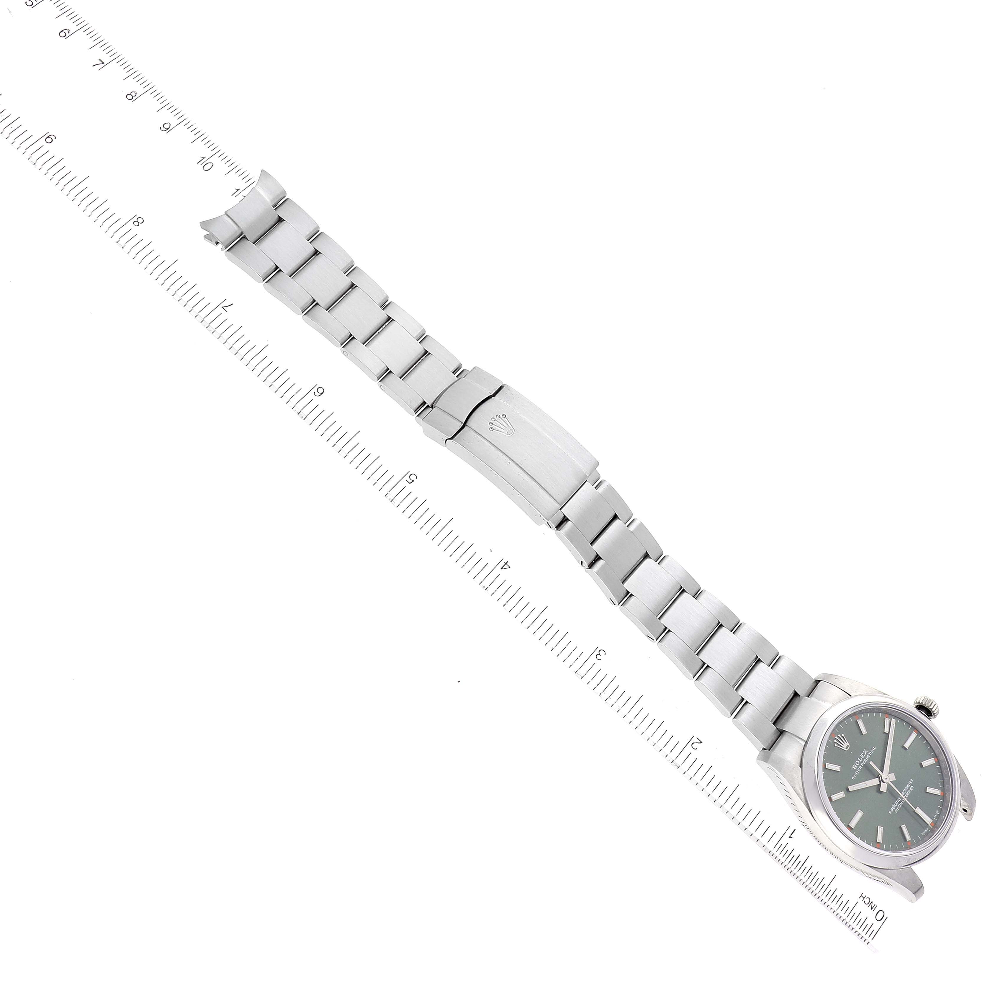This image shows an overhead view of the Rolex Oyster Perpetual 114200 Men
s Stainless Steel Green Dial 114200 Men
s Stainless Steel Green Dial watch and its silver bracelet fully extended with a ruler for scale.