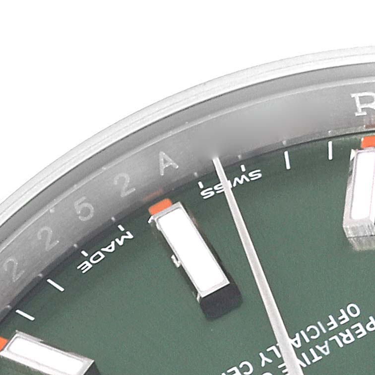 This image shows a close-up angle of the Rolex Oyster Perpetual 114200 Men
s Stainless Steel Green Dial 114200 Men
s Stainless Steel Green Dial watch face, highlighting hour markers and part of the dial.