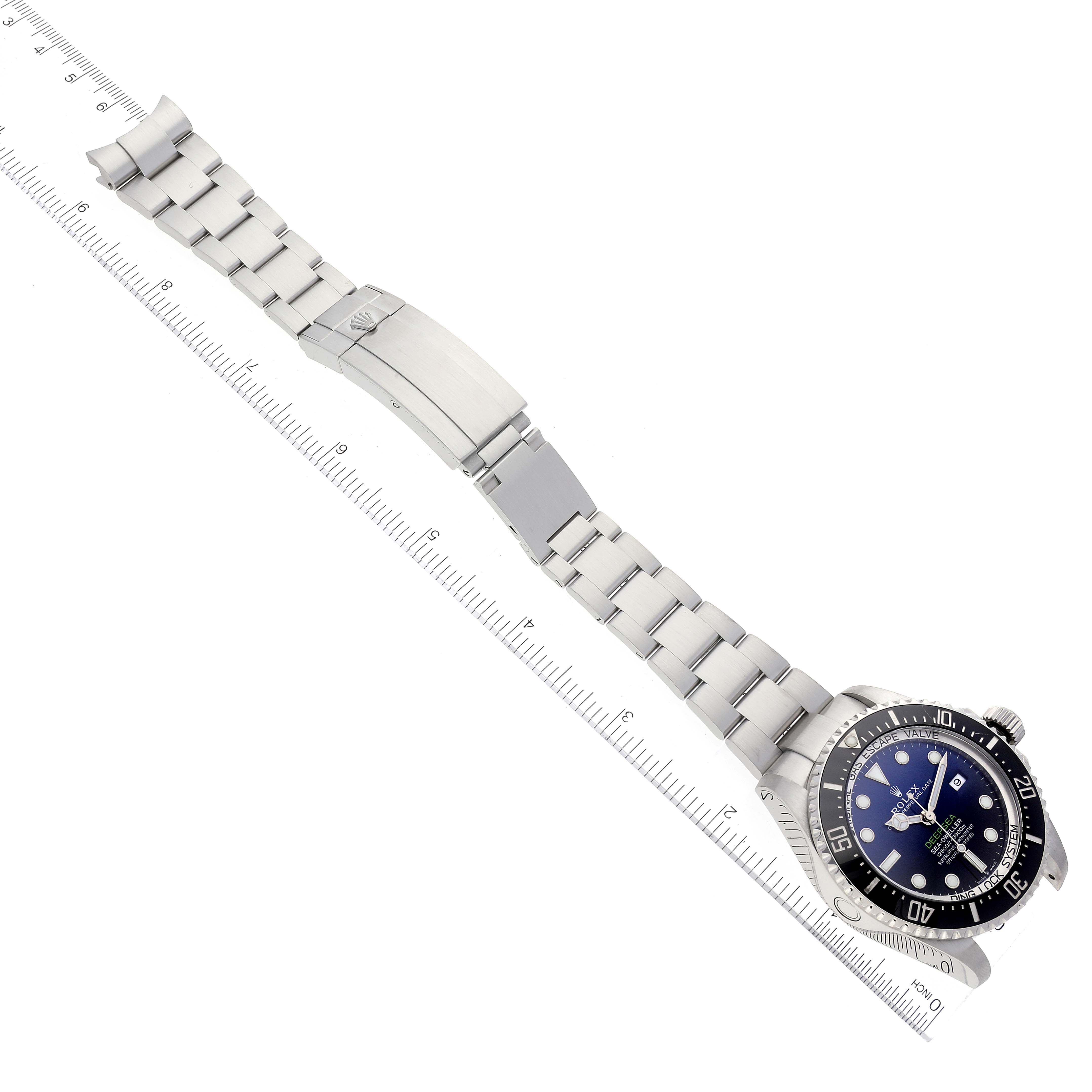 The image shows a top-down view of a Rolex Sea-Dweller 126660 Men's Stainless Steel Blue Dial 126660 Men's Stainless Steel Blue Dial watch with its bracelet fully extended alongside a measuring ruler.