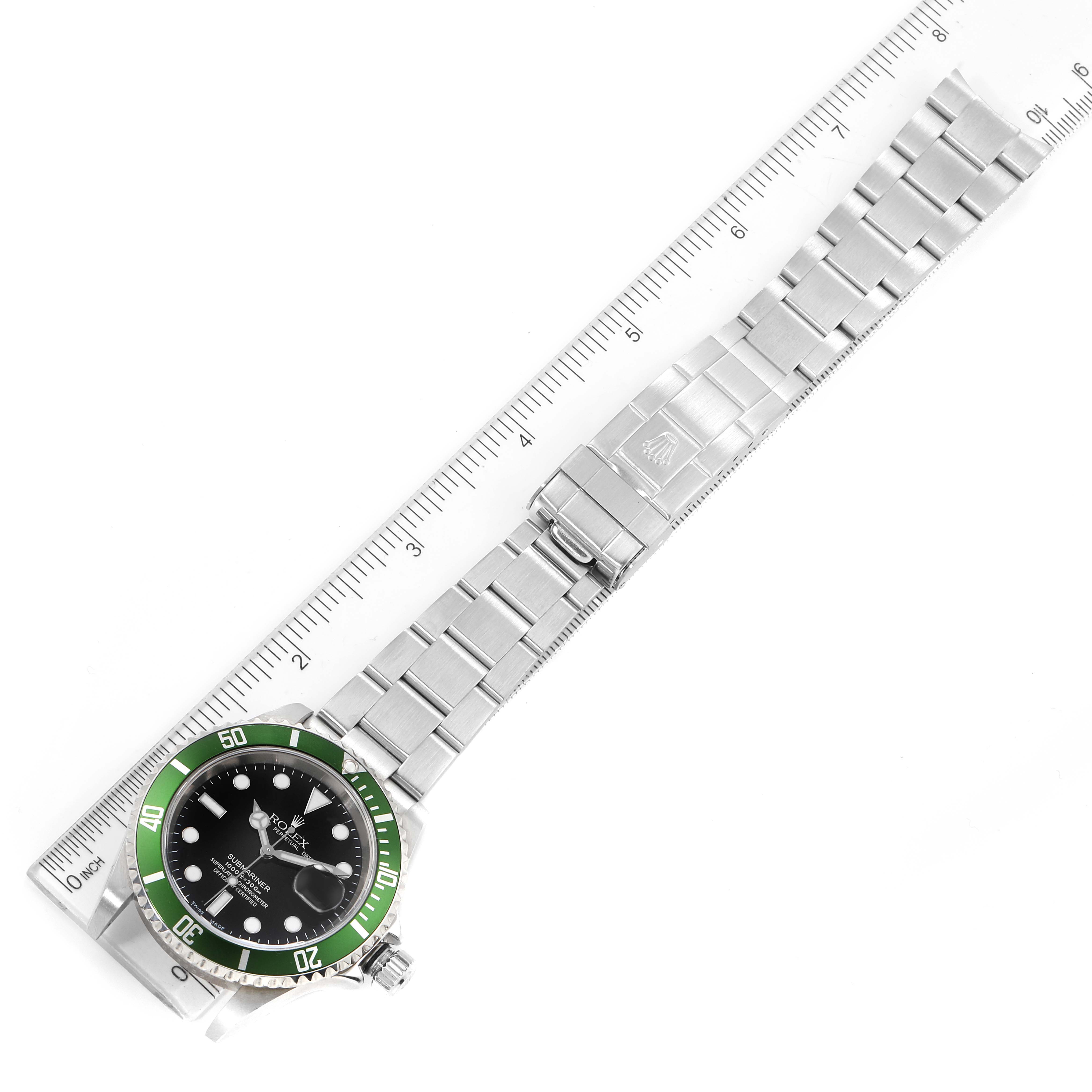 The image shows a Rolex Submariner 16610LV Men
s Stainless Steel Black Dial 16610LV Men
s Stainless Steel Black Dial watch laid flat alongside a ruler, displaying its face, bezel, and bracelet.