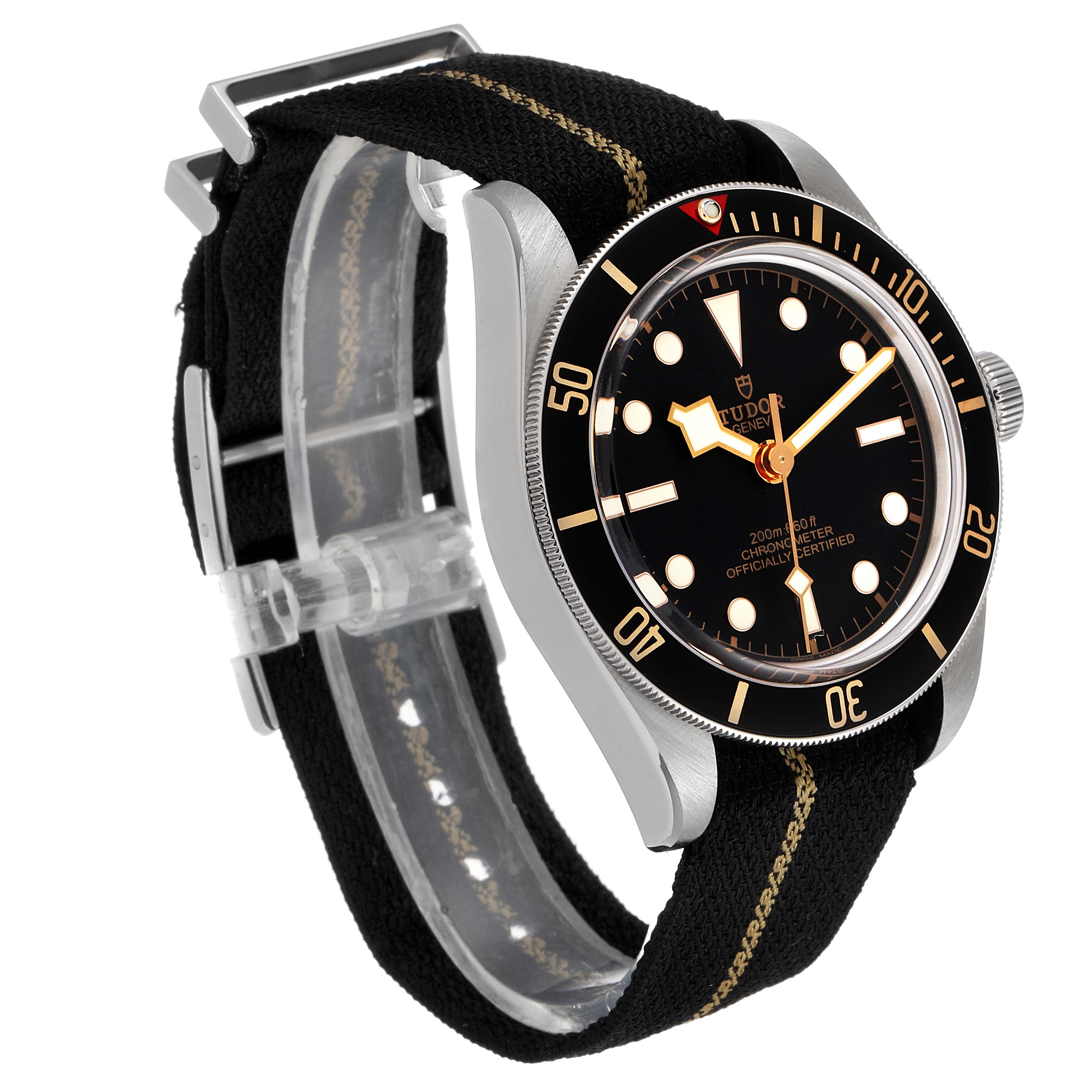 The image shows a Tudor Heritage Black Bay 79030N Men
s Stainless Steel Black Dial 79030N Men
s Stainless Steel Black Dial watch from a three-quarter angle, highlighting the case, bezel, and fabric strap.