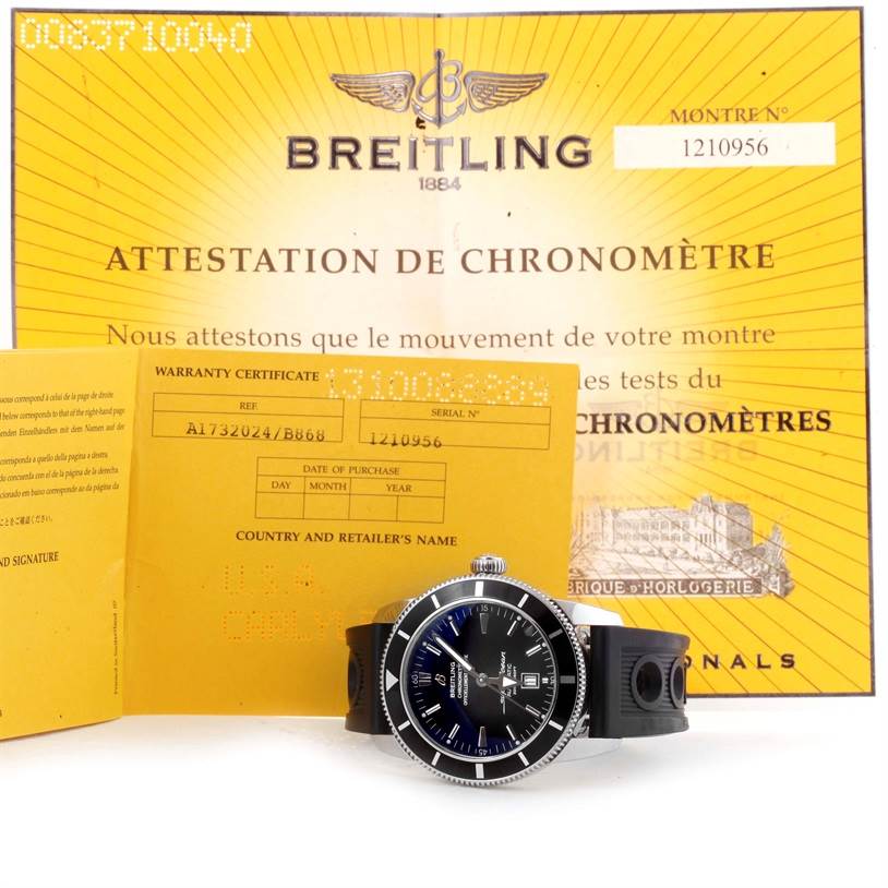 This image features a Breitling Superocean A17320 Men's Stainless Steel Black Dial A17320 Men's Stainless Steel Black Dial watch displayed at an angle alongside its warranty certificate and chronometer attestation.