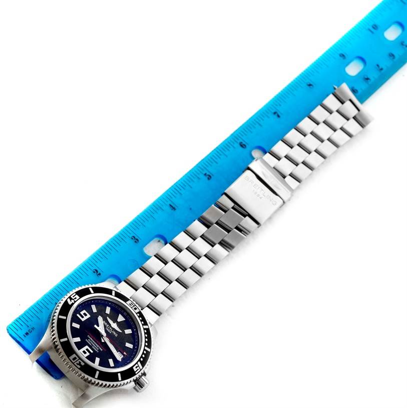 The image shows a Breitling Superocean A17391 Men's Stainless Steel Black Dial A17391 Men's Stainless Steel Black Dial watch laid flat next to a ruler, displaying the watch face and metal bracelet band.