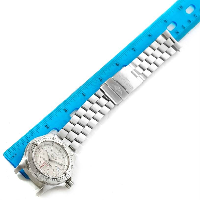 The image shows the Breitling Superocean A17390 Men's Stainless Steel Beige Dial A17390 Men's Stainless Steel Beige Dial watch laid flat, with its face, bezel, and metal bracelet visible alongside a measuring ruler.