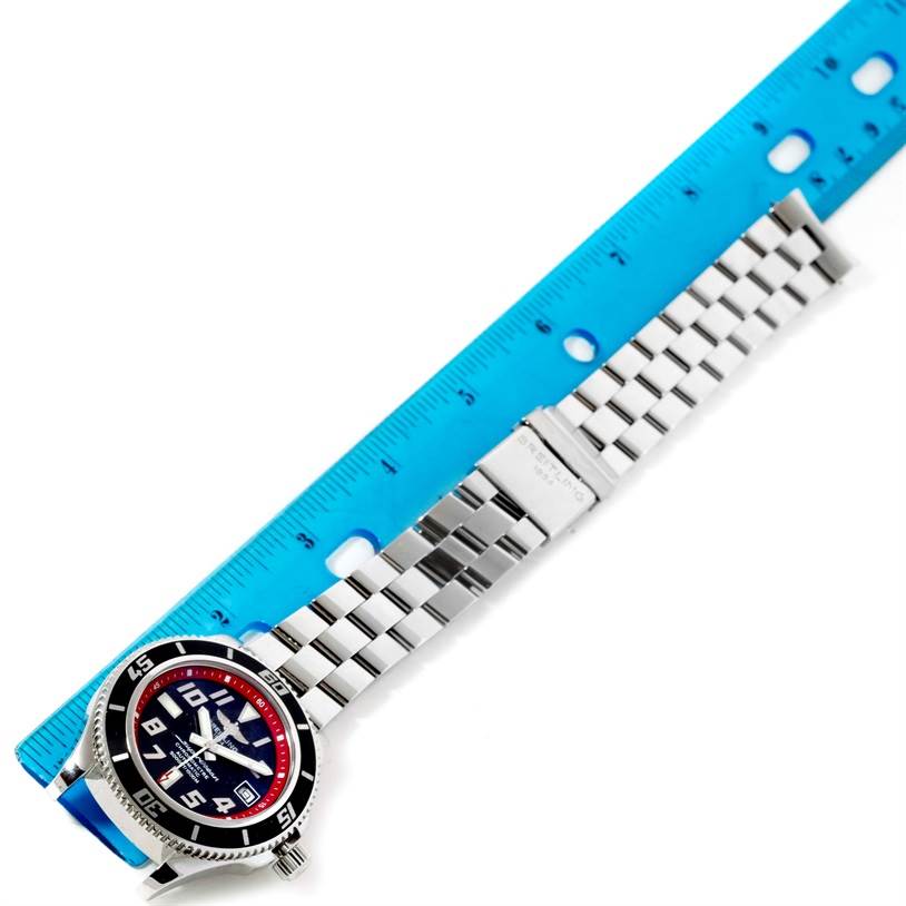 The image shows a Breitling Superocean A17364 Men's Stainless Steel Black Dial A17364 Men's Stainless Steel Black Dial watch from an overhead angle, with the face and stainless steel bracelet alongside a blue ruler.