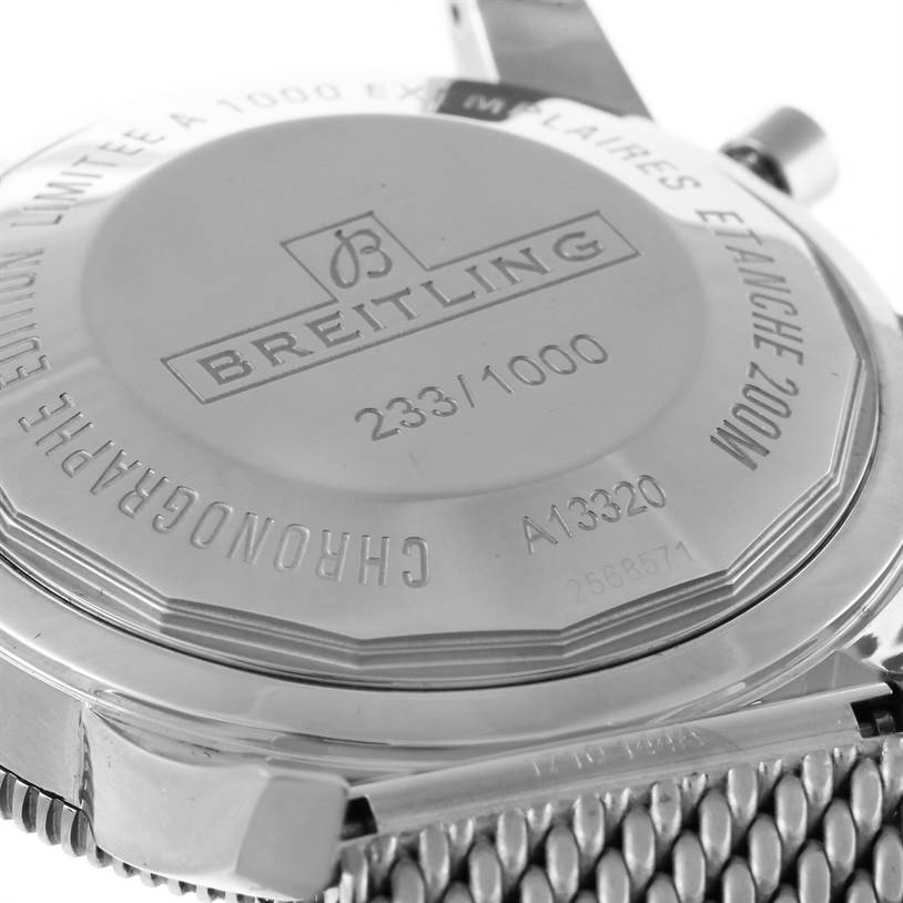 The image shows the back case of a Breitling Superocean A13320 Men's Stainless Steel Black Dial A13320 Men's Stainless Steel Black Dial watch, highlighting its engravings and part of the mesh bracelet.
