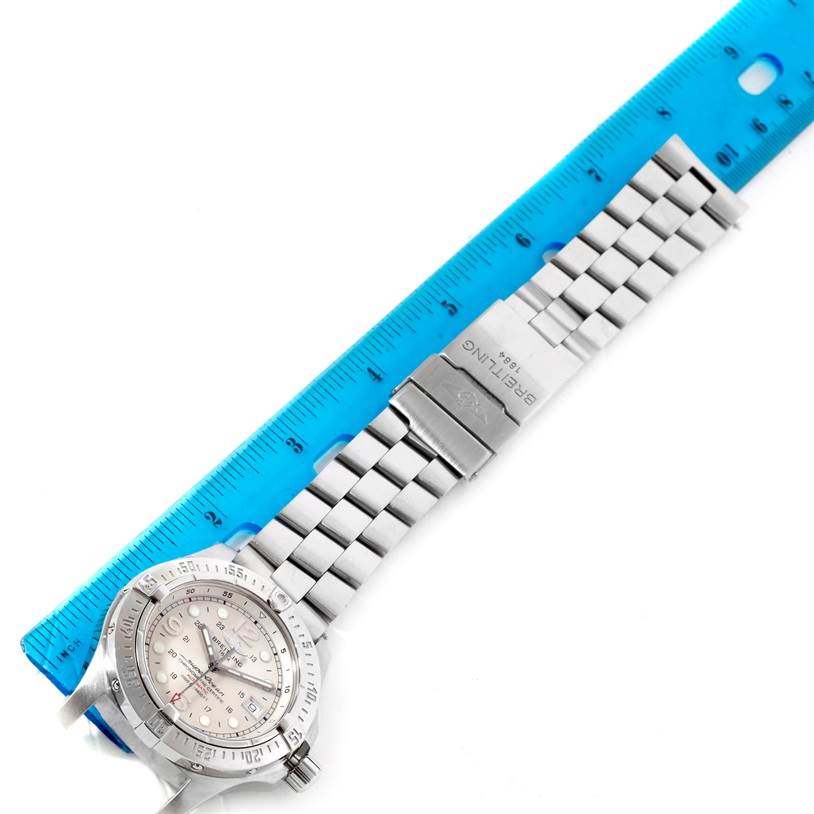 This image shows a top view of a Breitling Superocean A17390 Men's Stainless Steel White Dial A17390 Men's Stainless Steel White Dial watch with a metal bracelet and deployment clasp, placed next to a blue ruler.