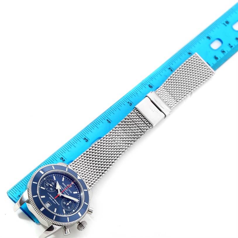 The Breitling Superocean A2337016-C856-154A Men's Stainless Steel Blue Dial A2337016-C856-154A Men's Stainless Steel Blue Dial watch is shown at an angled top view with the face, mesh strap, and clasp visible against a measuring ruler.