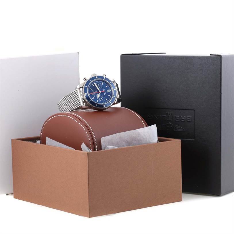 The Breitling Superocean A2337016-C856-154A Men's Stainless Steel Blue Dial A2337016-C856-154A Men's Stainless Steel Blue Dial watch is shown at a three-quarter angle, displayed on a brown leather pillow with black and white packaging.