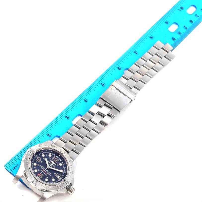 The image shows a Breitling Superocean A17390 Men's Stainless Steel Blue Dial A17390 Men's Stainless Steel Blue Dial watch with a blue dial and stainless steel bracelet, measured next to a blue ruler.