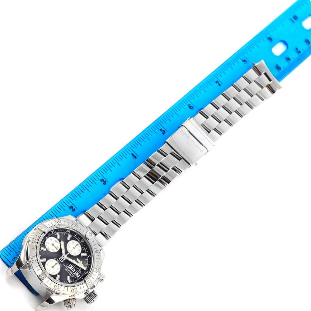 The image shows a top-down view of a Breitling Superocean A13340 Men's Stainless Steel Black Dial A13340 Men's Stainless Steel Black Dial watch with a stainless steel bracelet next to a blue ruler for scale.