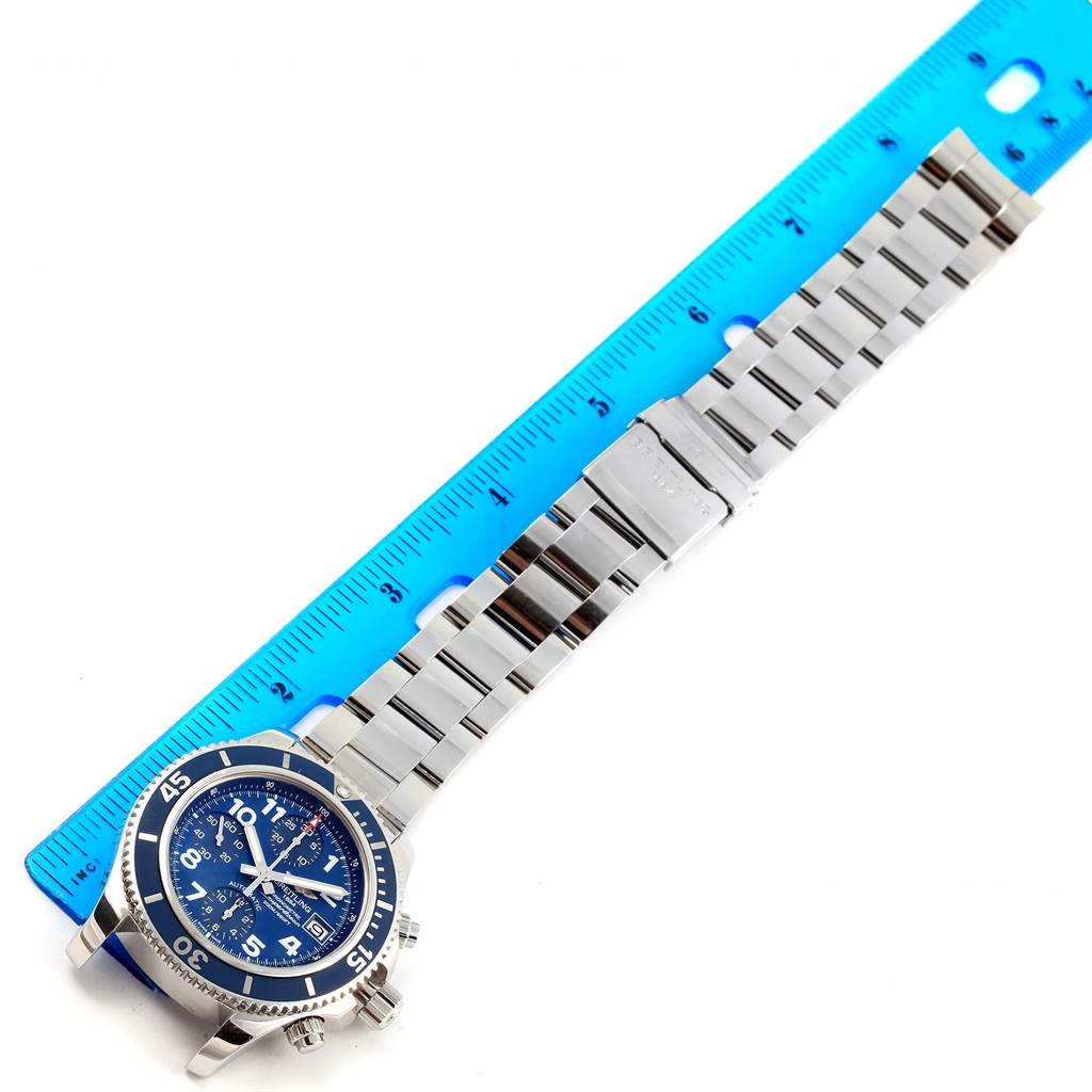 The Breitling Superocean A13311 Men's Stainless Steel Blue Dial A13311 Men's Stainless Steel Blue Dial watch is shown with its full bracelet and a blue ruler measuring its length.