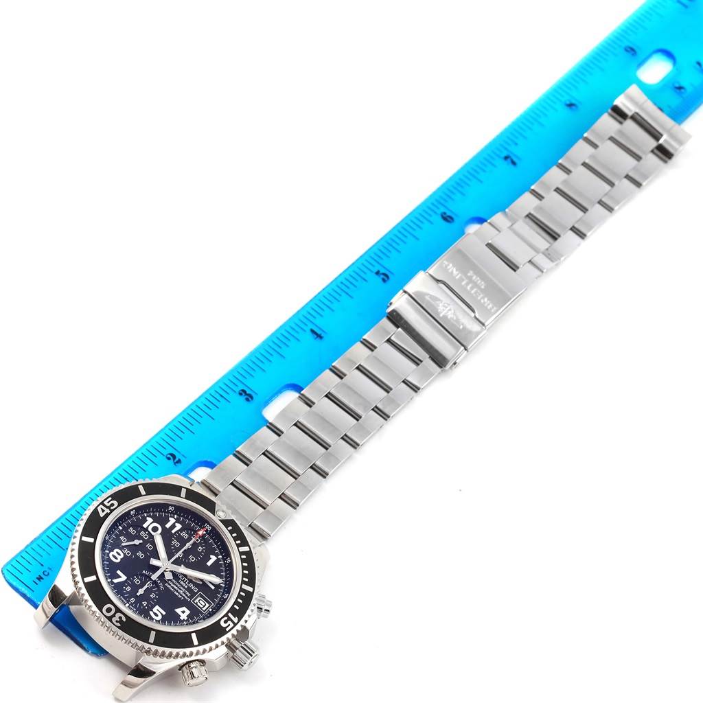 The Breitling Superocean A13311 Men's Stainless Steel Black Dial A13311 Men's Stainless Steel Black Dial watch is shown from a top view, displaying its face, bezel, and stainless steel bracelet placed alongside a ruler.