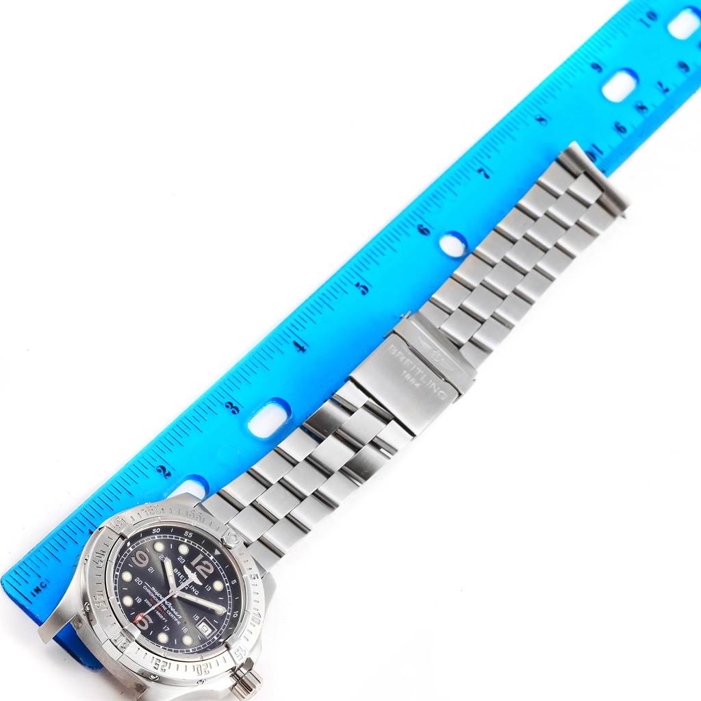 The image shows the Breitling Superocean A17390 Men's Stainless Steel Black Dial A17390 Men's Stainless Steel Black Dial watch laid flat next to a blue ruler, displaying the face, bezel, and metal bracelet.