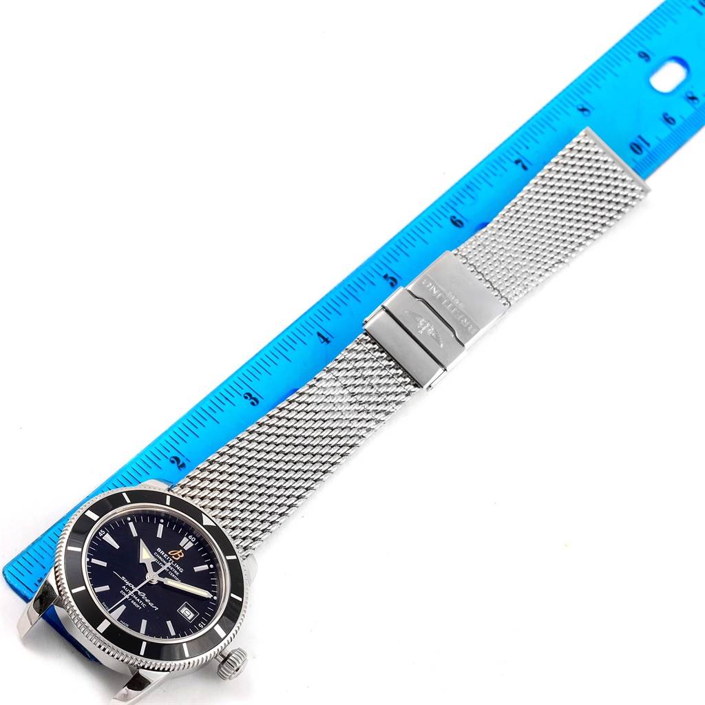 This image shows a Breitling Superocean A17321 Men's Stainless Steel Black Dial A17321 Men's Stainless Steel Black Dial watch at an angle, with its mesh bracelet stretched and measured against a blue ruler.
